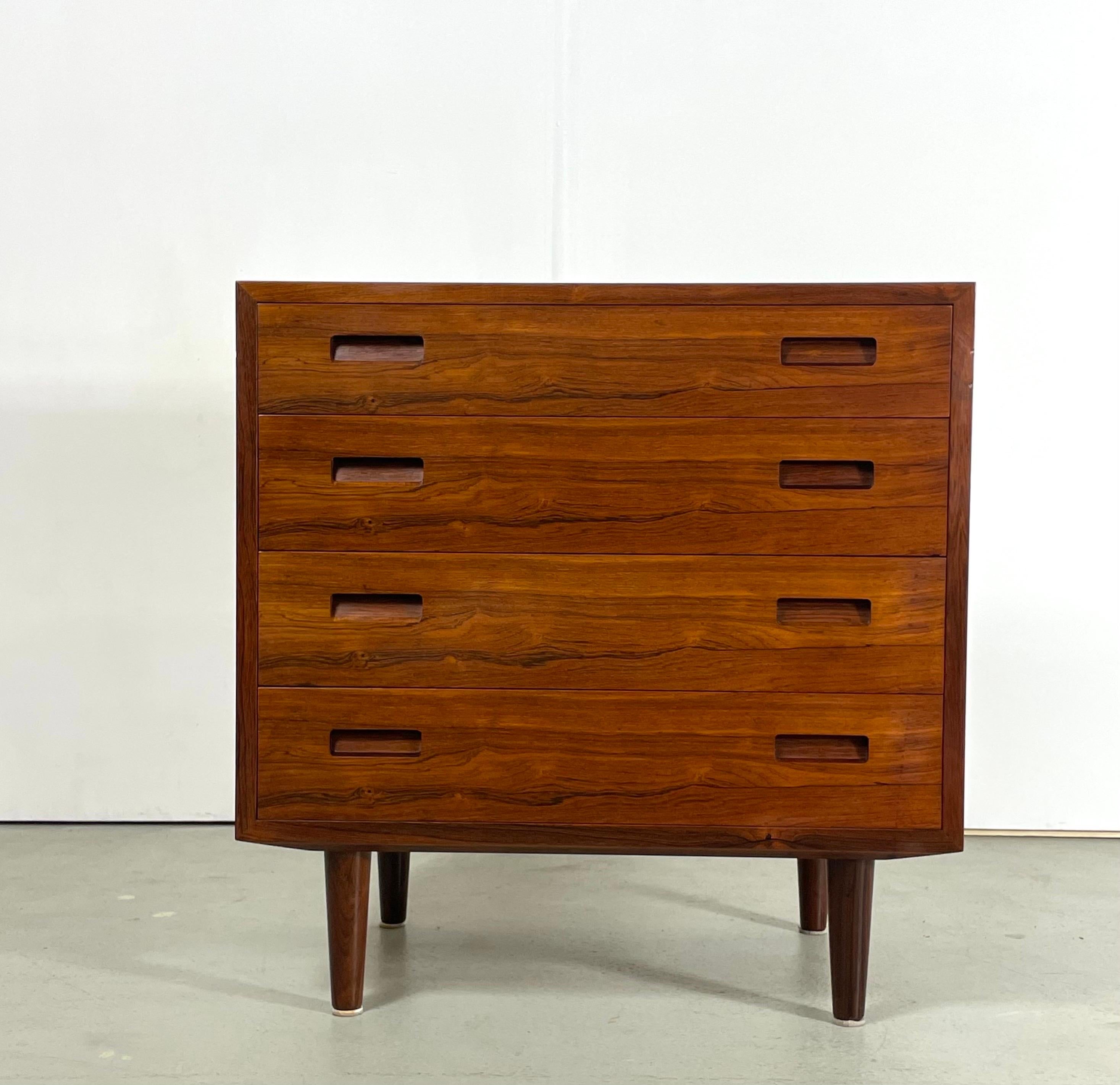 Mid-century chest of drawers designed by Carlo Jensen for Hundevad & Co. It was produced in Denmark during the 1950's. This is a rare piece made of rosewood which shows a remarkable wood grain. The high-quality craftsmanship is notable in the