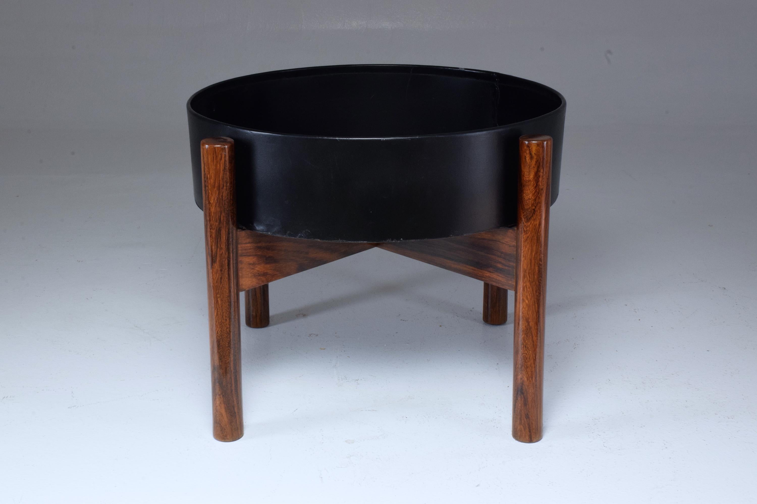 Striking 20th century vintage Scandinavian circular planter or jardinière, composed of a solid rosewood structure and a removable black lacquered metallic insert.
A rare midcentury model.
The wood has been re-varnished and it is possible to