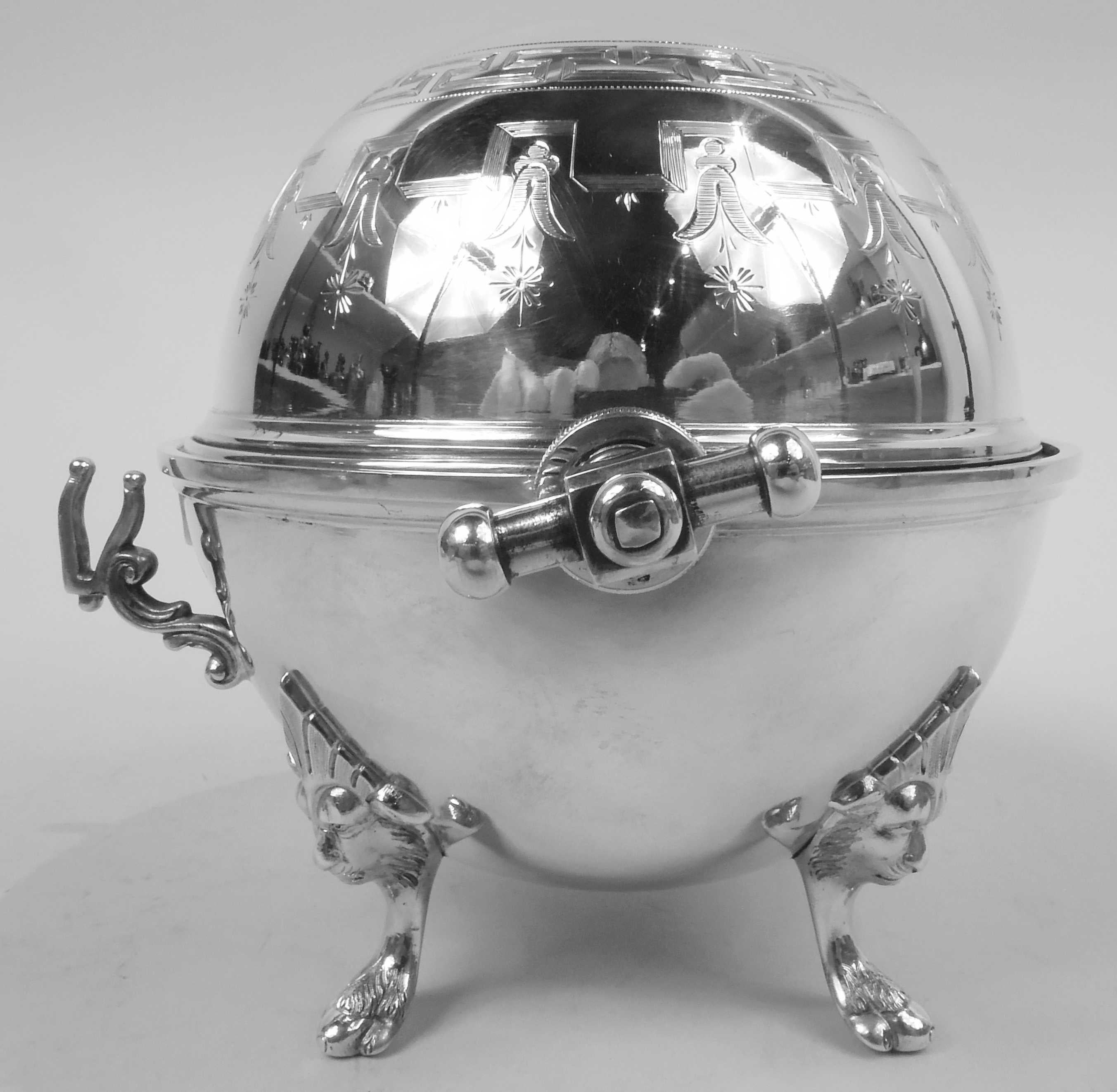 Classical silver butter dish. Made by Vilhelm Christensen in Copenhagen in 1890. Globular; cover hinged side disc and barbell mounts. Cast double-scroll mounted brackets for tongs and four lion head monopodium supports. Engraved fretwork and