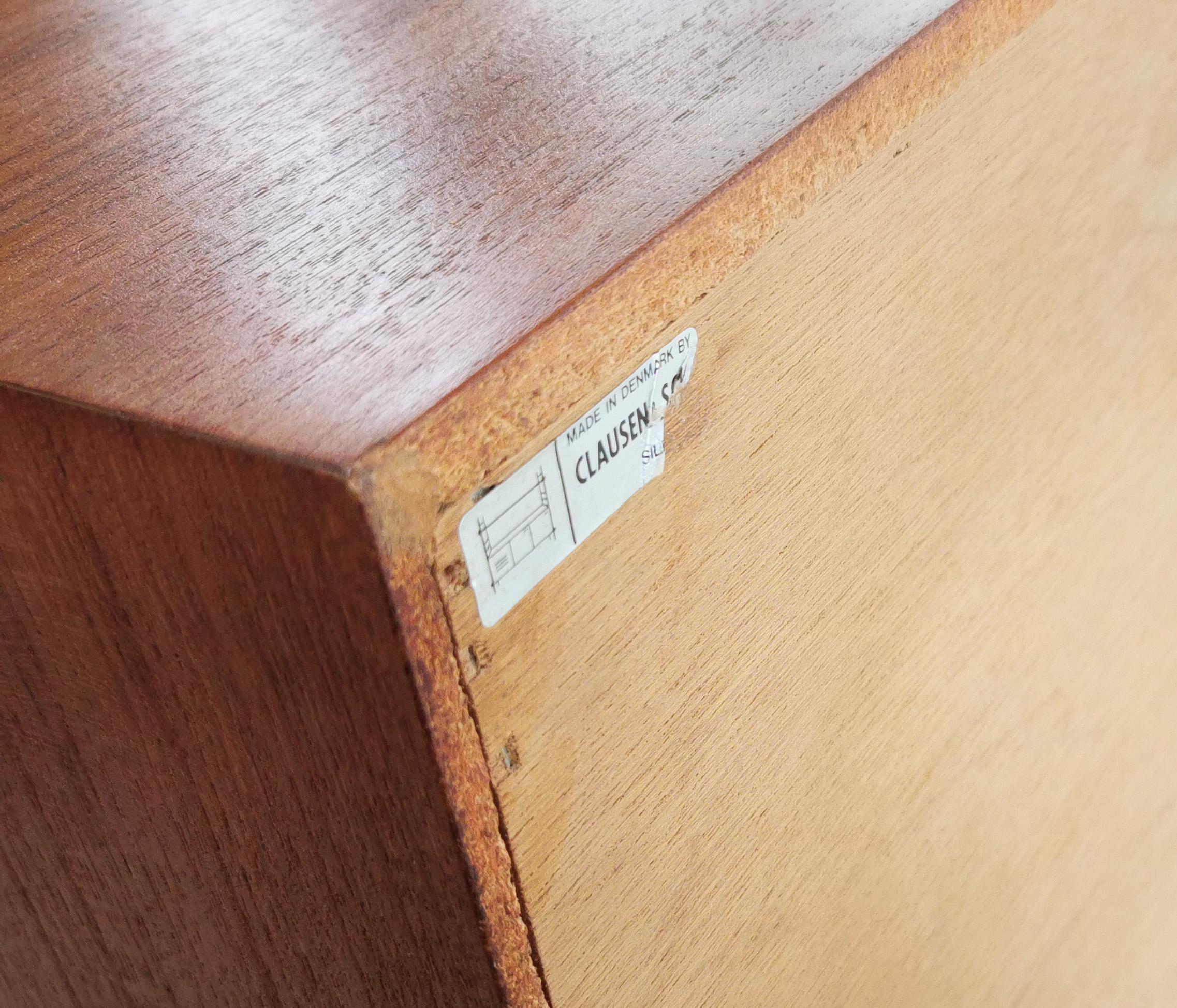 Danish teak sideboard

High-quality teak sideboard by Clausen & Son of Silkeborg, Denmark.

Typical Danish furniture item, designed to be simplistic and functional. 

The sideboard has a flight of four drawers in the middle next to sliding