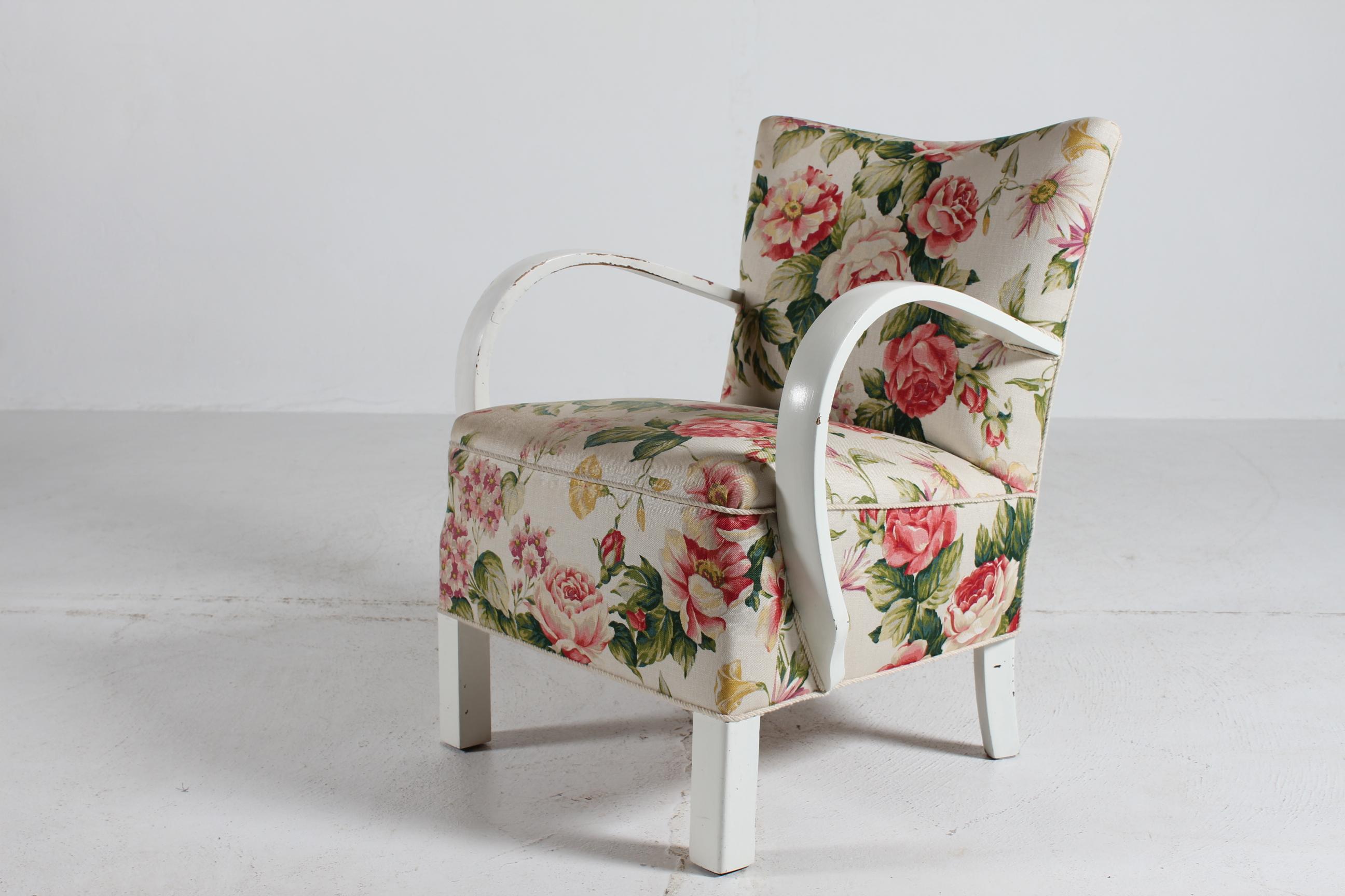 Fauteuil club et de salon danois des années 1940, recouvert d'un tissu à motifs floraux présentant des signes d'utilisation et d'âge.
Pieds et accoudoirs en bois avec peinture blanche patinée.

Fabriqué à la main dans les années 1940 par un