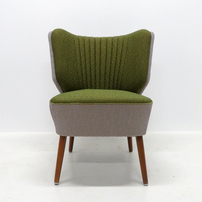 Wonderfully elegant original Danish cocktail chairs from 1950, with original spring supported seat cushions and riveted edge details on teak legs in great condition, the multi colored upholstery looks to be from a later date.