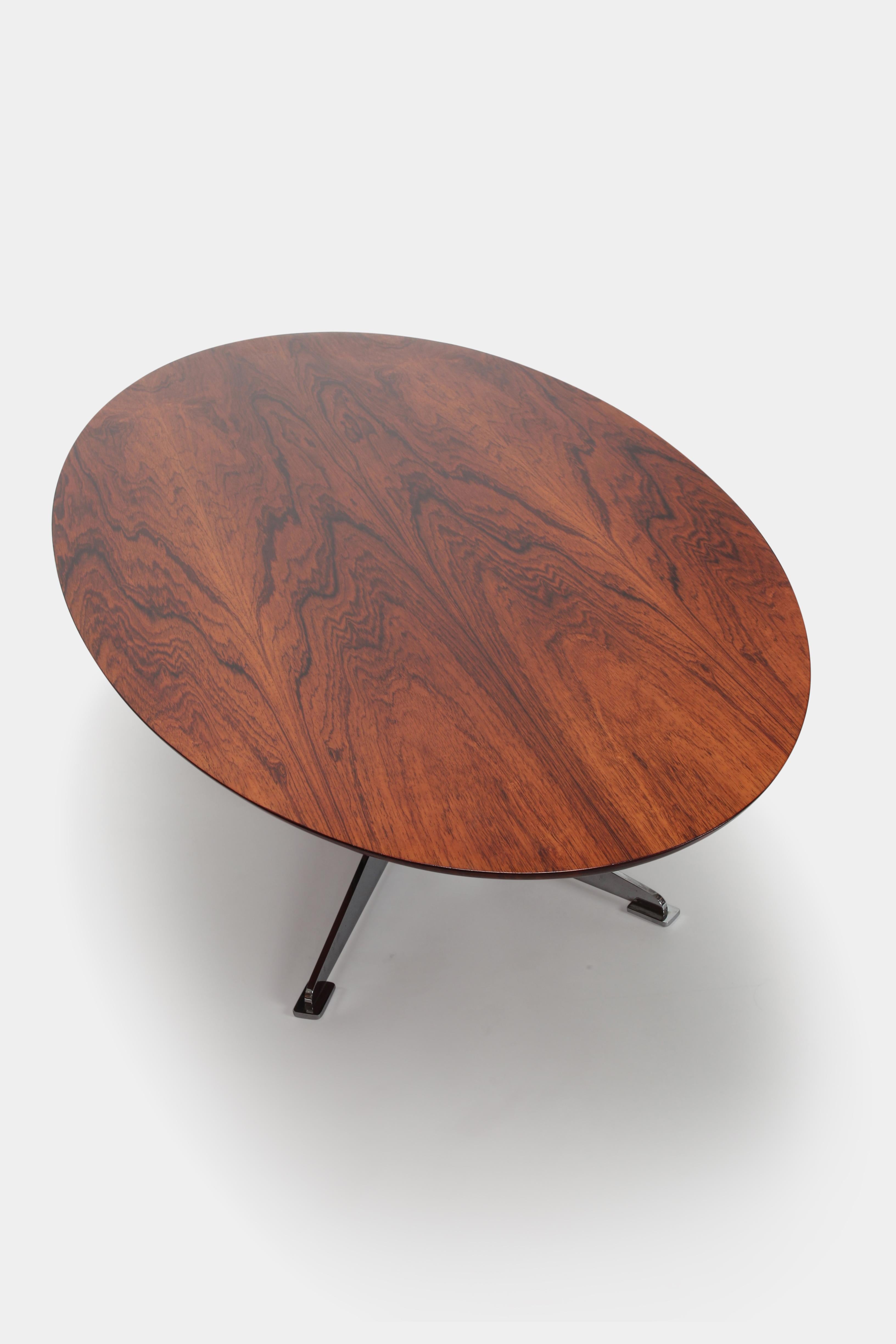 Danish coffee table manufactured in the 1970s. Stunning coffee table, customized. Oval tabletop made of beautiful grained Brazilian rosewood on a edgy chrome steel base. The table top was professionally new lacquered.
 