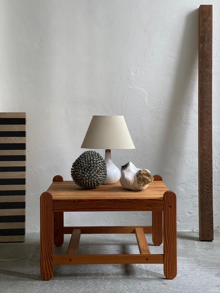 Rare and elegant 1970s danish coffee table in aged solid pine and brass joinery. In very good vintage condition. Designed by danish architect Peter Ole Schiønning for Niels Eilersen. Labeled with 