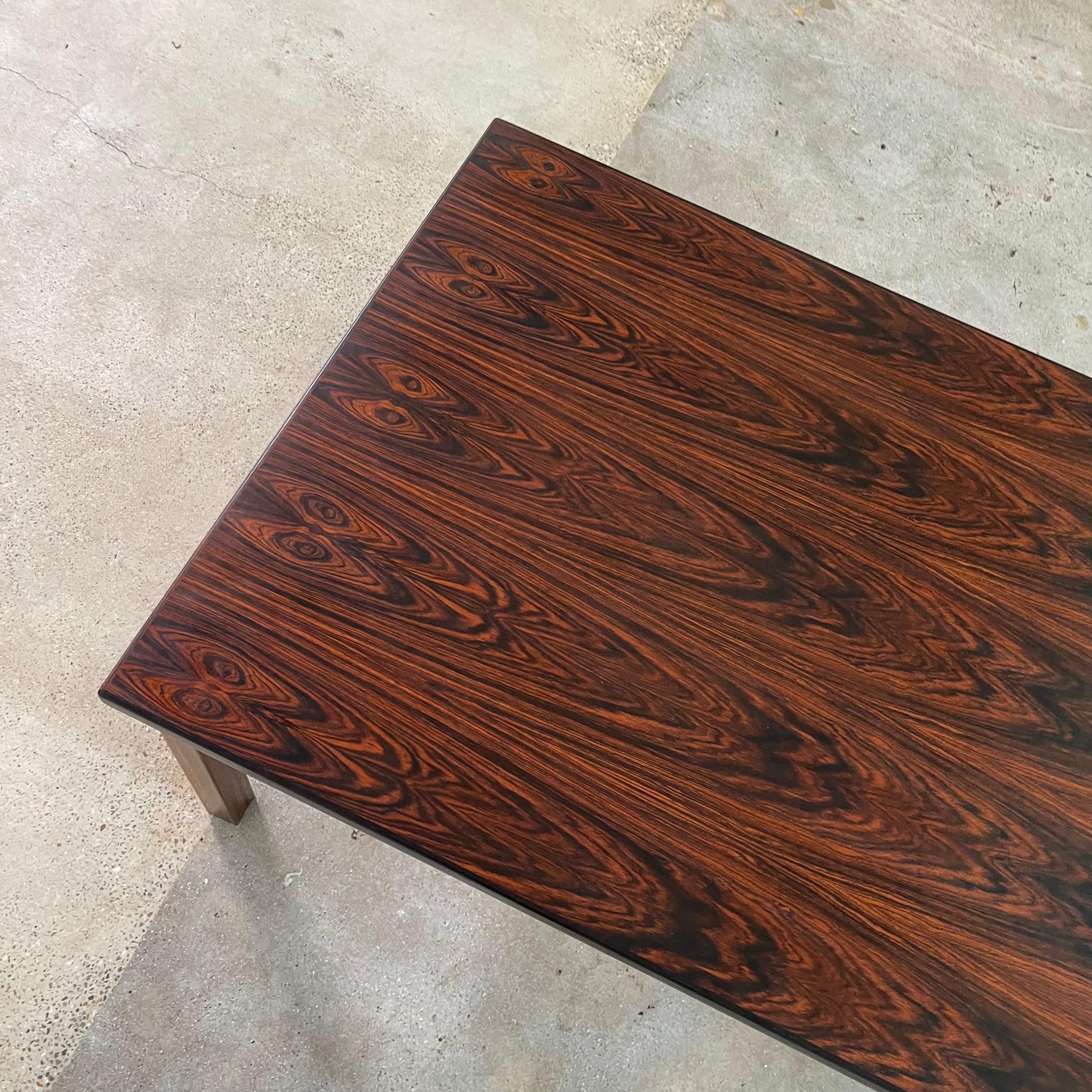 Danish Mid-Century Modern coffee table in rosewood. Very elegant and Classic design with striking wood grains and clean lines. This piece of rosewood is bursting with movement and the simple design allows for the raw materials to shine.