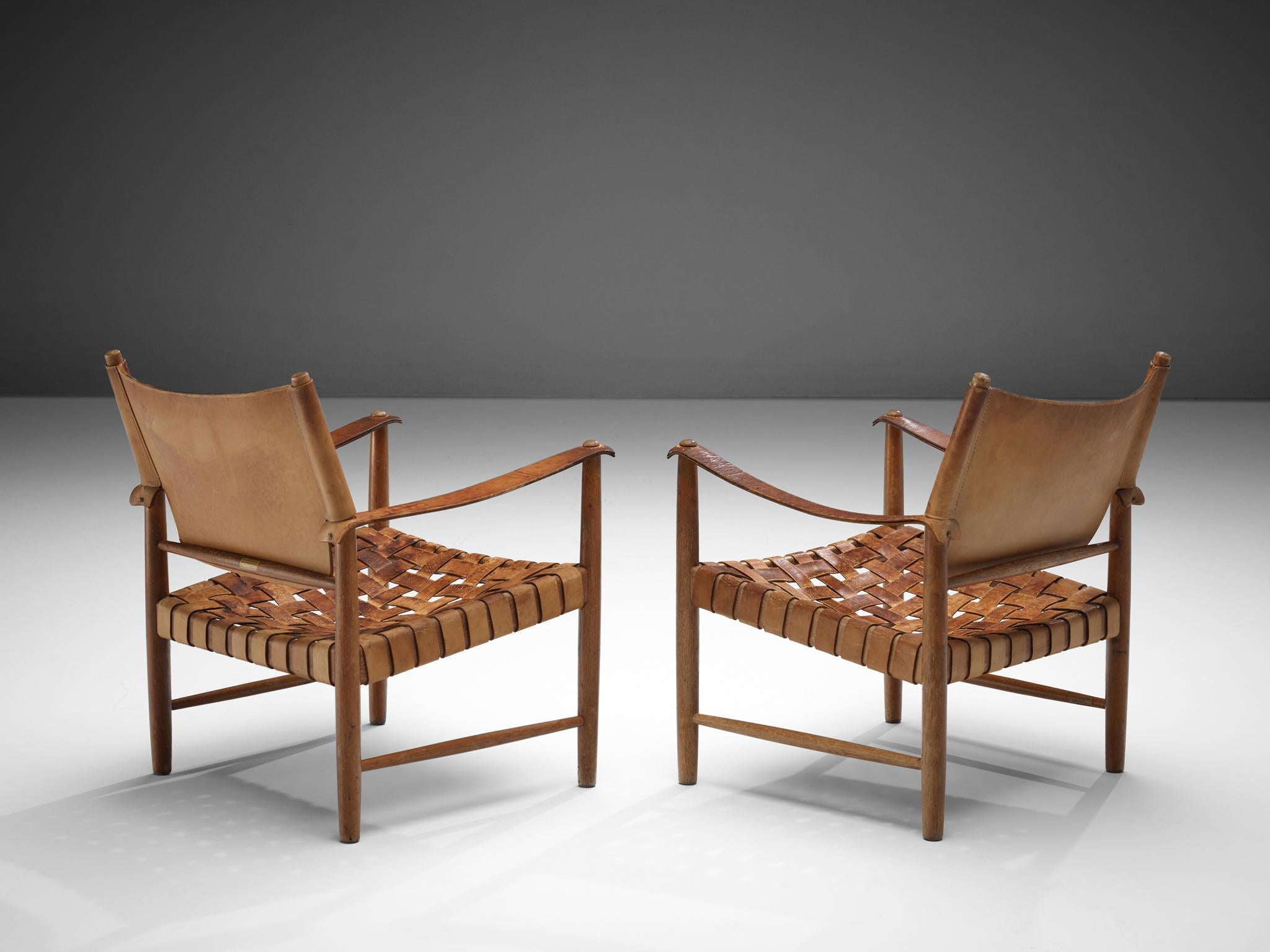 Pair of Danish safari chairs, patinated leather, oak, Denmark, 1950s. 

This elegant set safari chairs features wonderful patinated leather on both the seat, the arms and back. The patina creates a vibrant look which you can only achieve after years