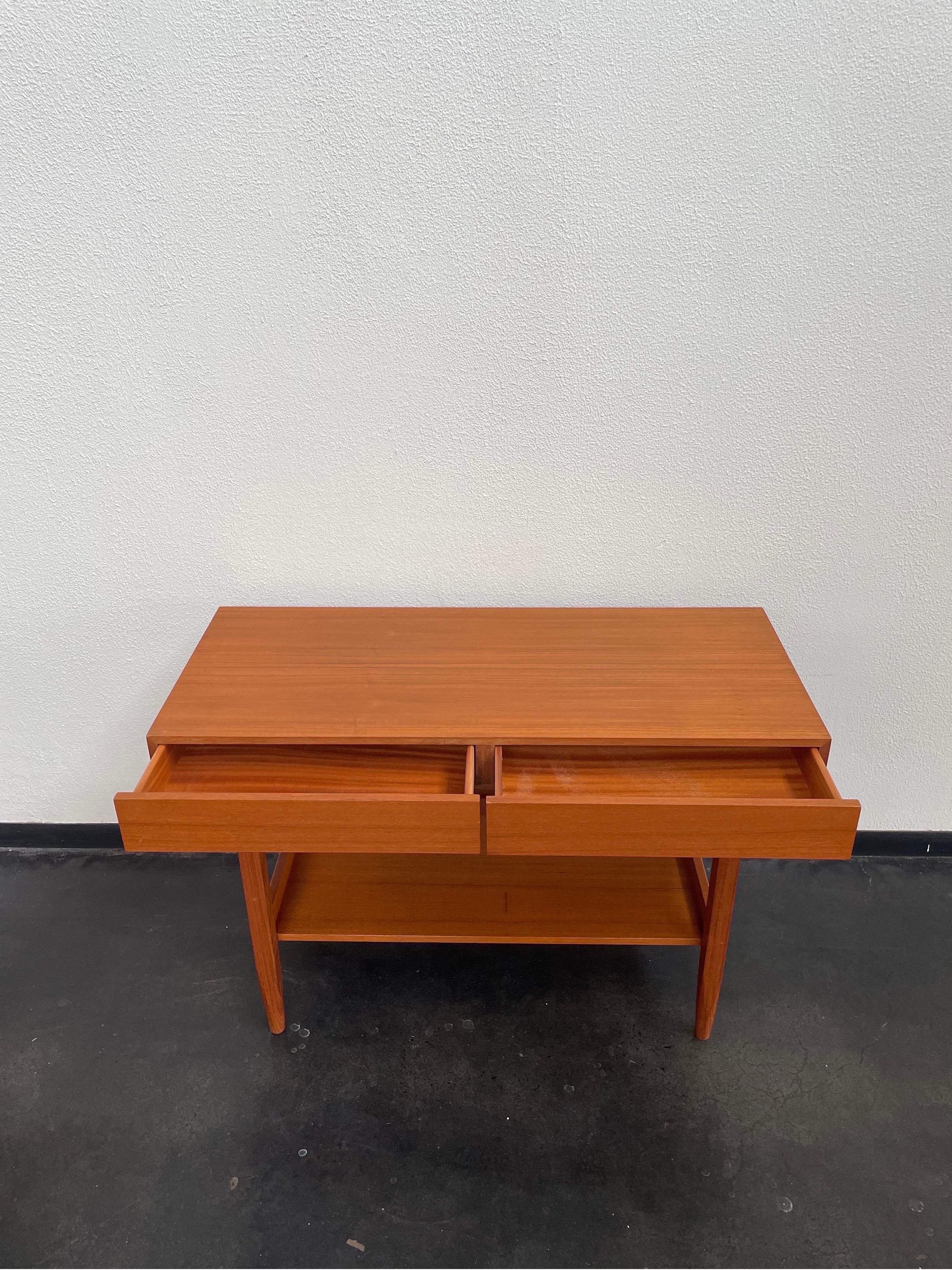 Vintage Mid-Century Modern teak Danish console table by Ib Kofod Larsen for Faarup Mobelfabrik. Featuring two drawers and a shelf underneath.