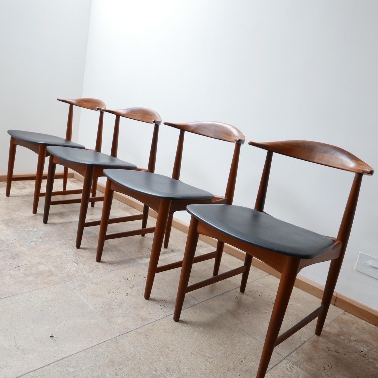 An immaculate set of four dining chairs.

Denmark, circa 1960s.

Teak construction with black leather upholstered seats.

In the manner of Hans J Wegner or Knud Faerch.

Dimensions: 48 W x 50 D x 44 seat height x 72 total Height in cm.