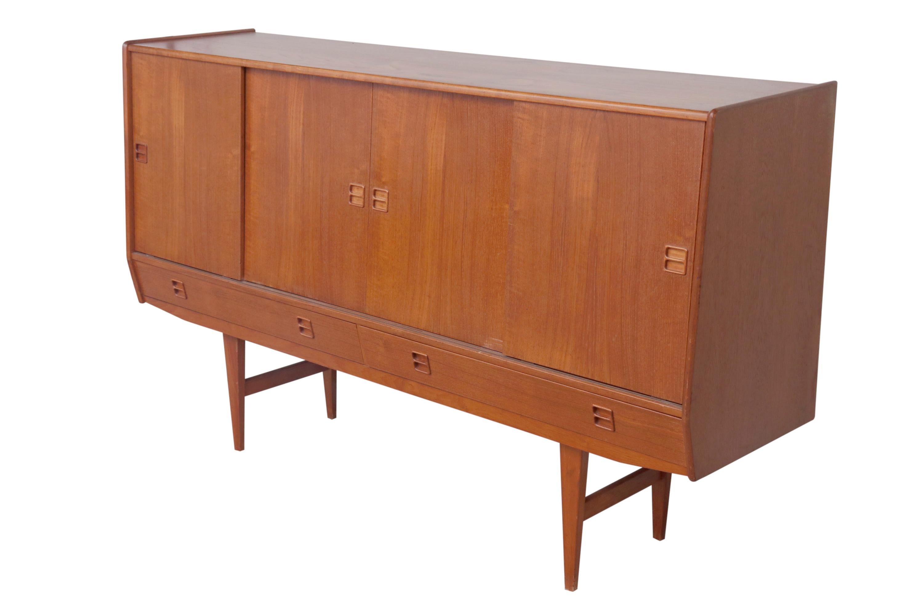 A large teak credenza in the Danish taste. Height measures: 41 inches sliding doors reveal considerable storage. Wonderful color and function.