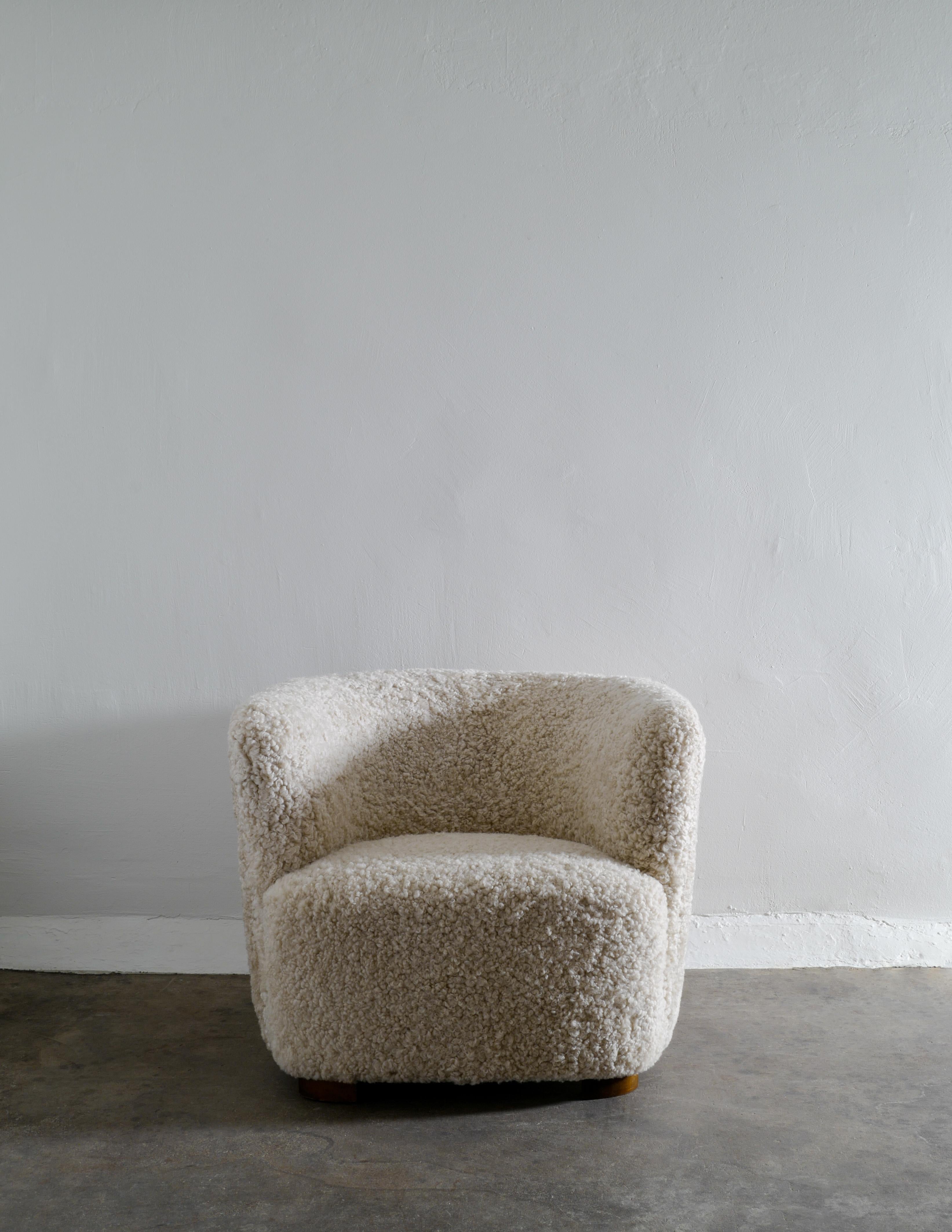 Rare curved easy chair produced in Denmark in the 1940s by unknown designer. Fully restored and upholstered in sheepskin. Oak feet. Attributed to Flemming Lassen and Viggo Boesen. 

Dimensions: H: 67 cm W: 85 cm D: 85 cm SH: 38 cm.