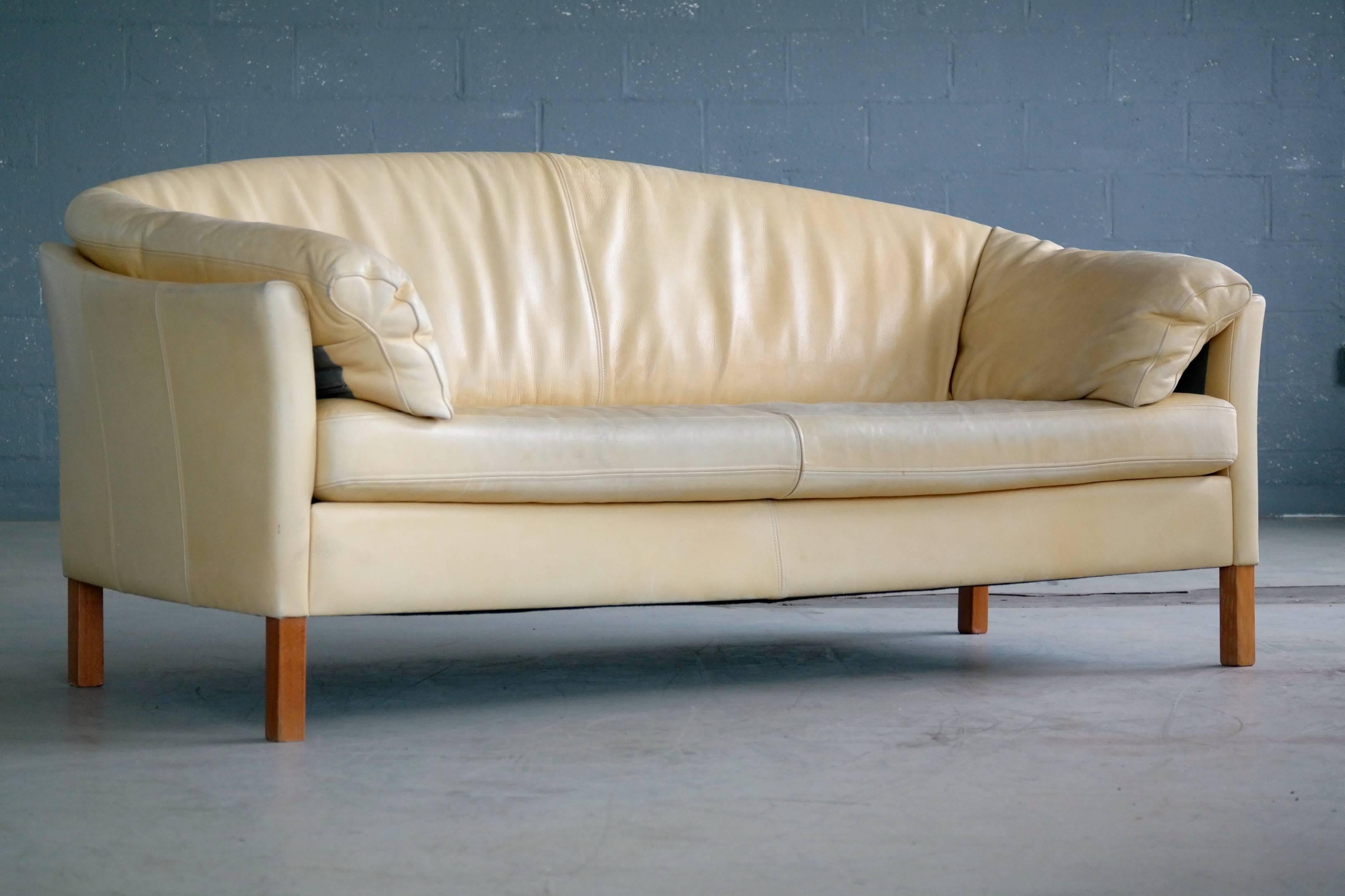 Very plush and classically styled three-seat sofa model MH535 made by Mogens Hansen in top grain aniline leather with beech wood legs. The sofa is a nice modern take on the banan form sofas of the 1940s and was designed around the late 1960s and