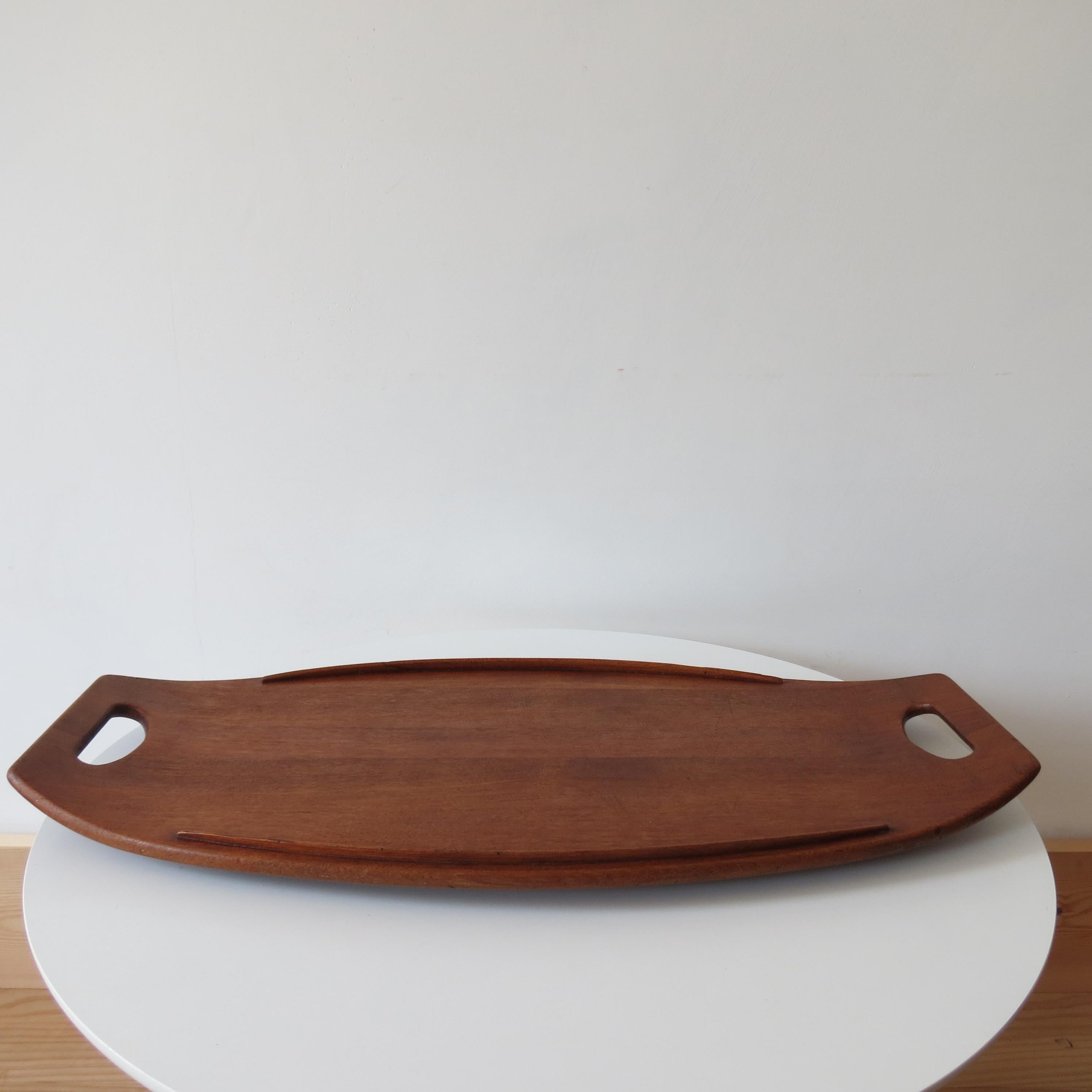 Teak tray designed by Jens Quistgaard for Dansk Design, 1950s.

Solid teak, in good vintage condition, some wear and marks to the top. Stamped Dansk Design, Denmark.

Small burn mark to the underside as shown in the photo.

Measures: 60cm x