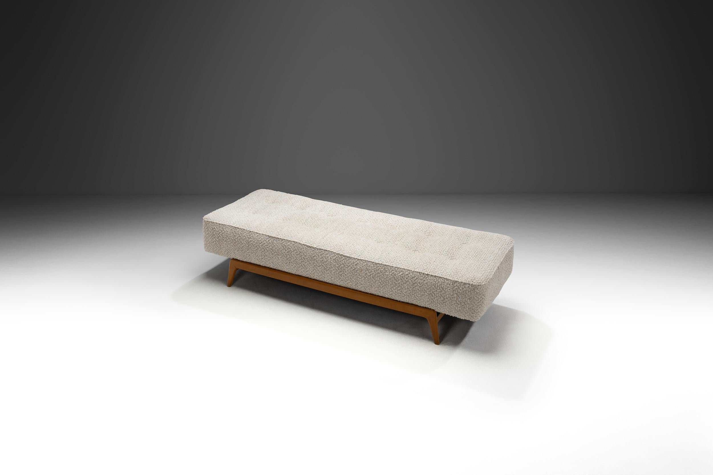Este impresionante sofá cama danés, tapizado en lujosa tela bouclé, encarna las líneas limpias y la belleza funcional que definen el diseño moderno escandinavo de mediados de siglo. Fabricado en Dinamarca en la década de 1970, el sofá cama ofrece