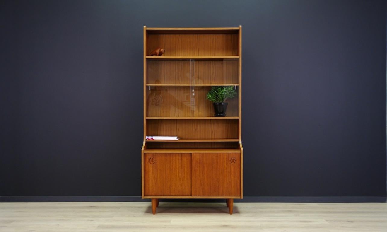 Original bookcase or cabinet of the 1960s or 1970s. Spacious interior with board behind sliding doors. Boards height adjustable. Veneered with teak. Item in good condition (small scratches and dings are visible, veneer losses filled).

Dimensions: