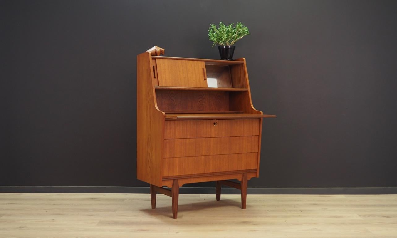 Vintage bureau from the 1960s-1970s - Danish design. A exceptional form finished with teak veneer. The secretary has a writing desk and practical drawers, which top is lockable with a key. At the top mirror behind sliding doors. Preserved in good