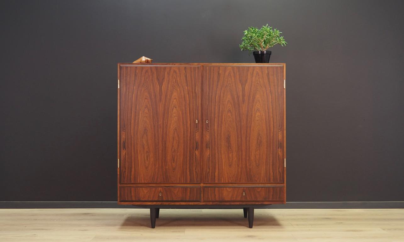 Fantastic cabinet from the 1960s-1970s, Danish design. The surface is veneered with a rosewood. Item has a roomy interior with shelves, and two external drawers. The key in the set. Preserved in good condition (small bruises and scratches) -