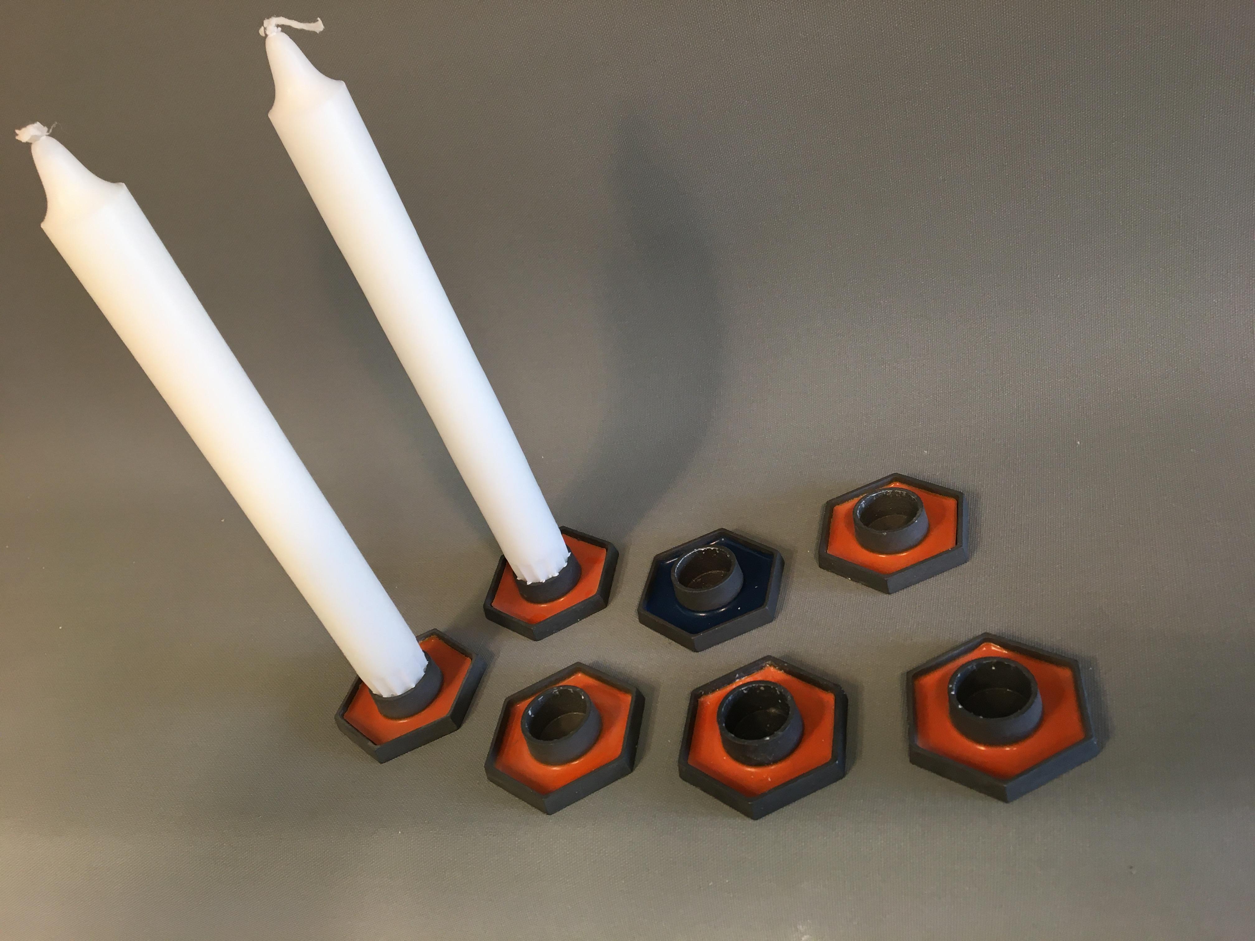 Candle holder Danish Design. Made in Denmark. 'Mønster beskyttet Paro'
Hexagonal candlesticks in orange, and a single blue to ordinary size candle.
The candlesticks are in iron with orange glaze.
Marked at the bottom with 'Design Made in Denmark'