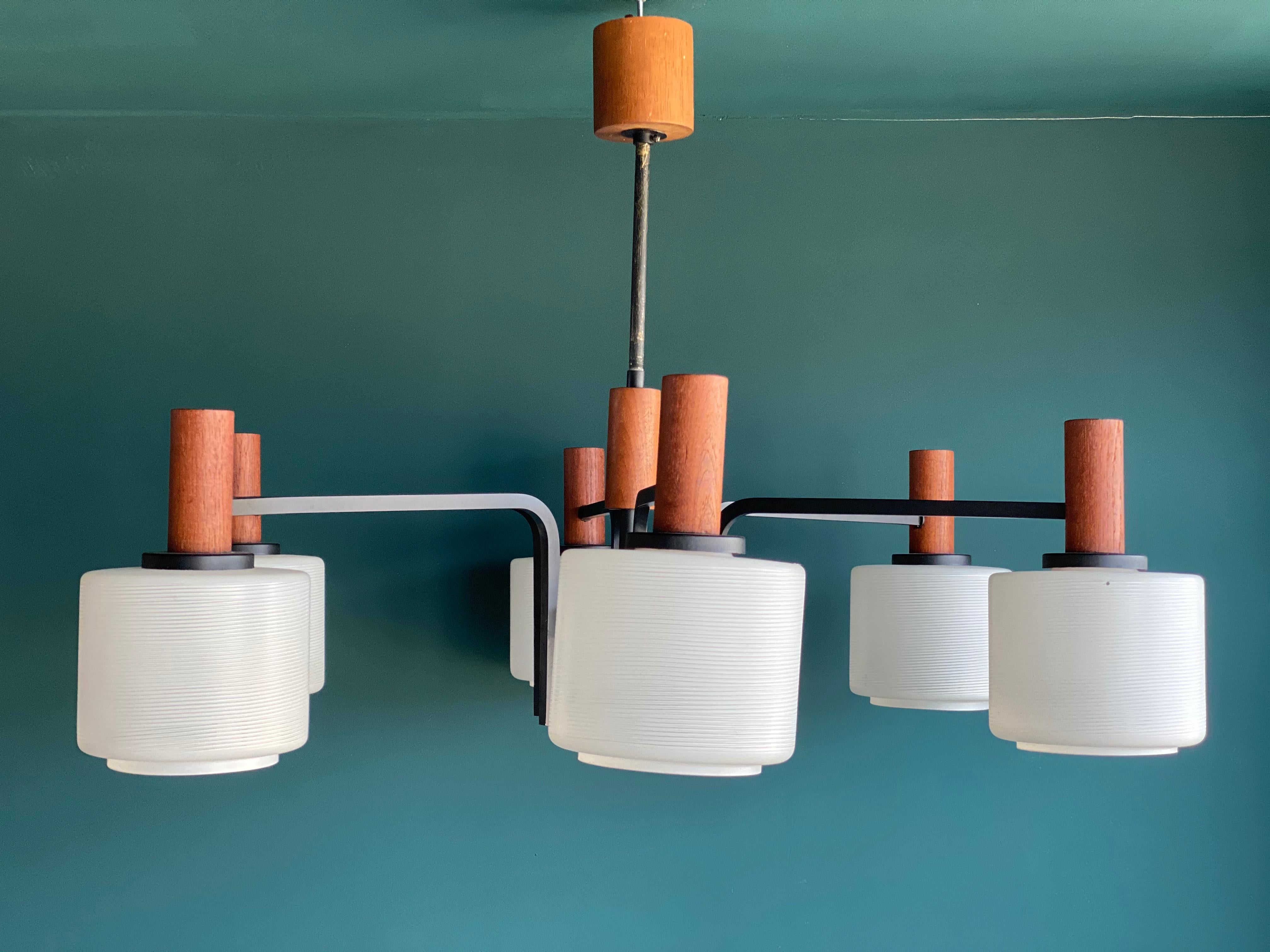 Beautiful Danish design chandelier from the 1960s. This typical Scandinavian midcentury piece has six chandelier arms with white lacquered fluted glass shades, which are held together by teak veneer covered joints. This chandelier is timeless in its