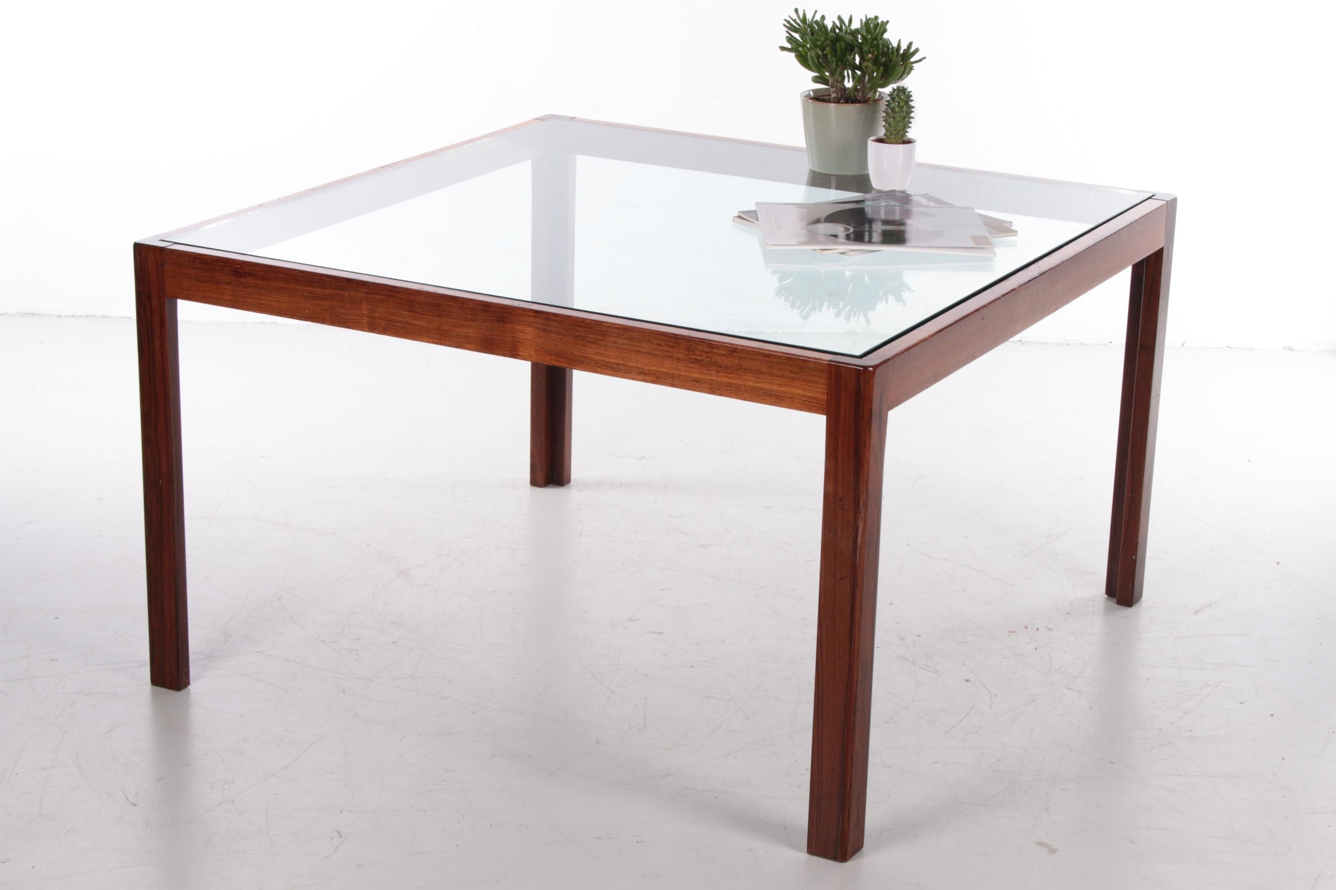 A beautiful square coffee table with a Wood frame and an inlaid glass top. 

The simple design points to typical Danish design, probably produced around the 1960s.

You can combine this table with various interior styles. 

The sleek design and the