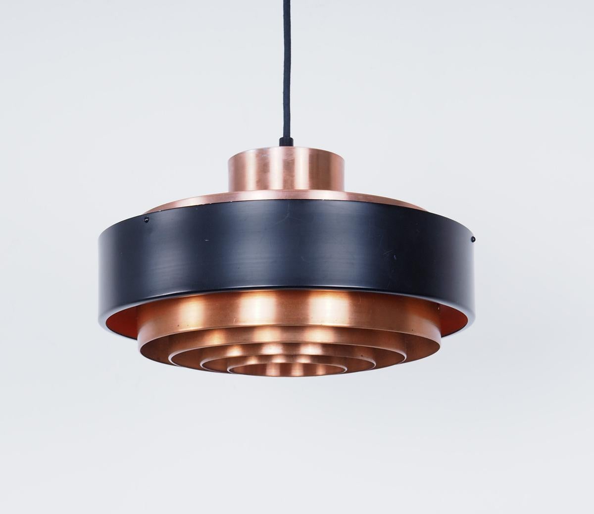 Vintage hanging lamp made of copper produced in Denmark in the 1960s.

The model looks a bit like Fog & Morup lamps.

The lamp has several layers of copper and a thick black band which spreads the light nicely.

The inside of the copper is lacquered