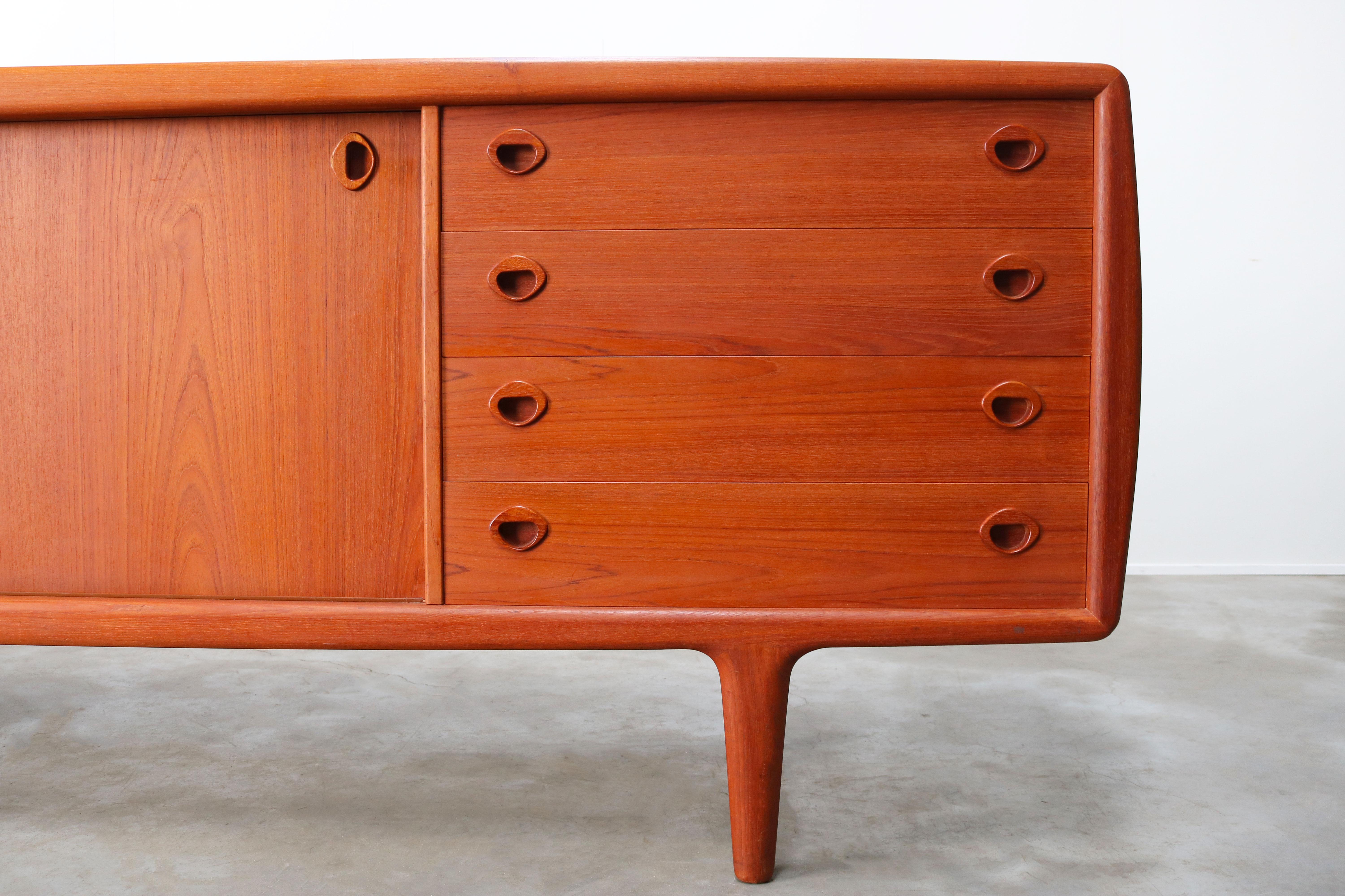Magnificent Danish design sideboard or credenza by H.P. Hansen in the 1950s. Wonderful organic sculpted teak with warm and beautiful wood grain.
The sideboard has 2 sliding doors and 4 drawers and multiple adjustable shelves providing plenty of