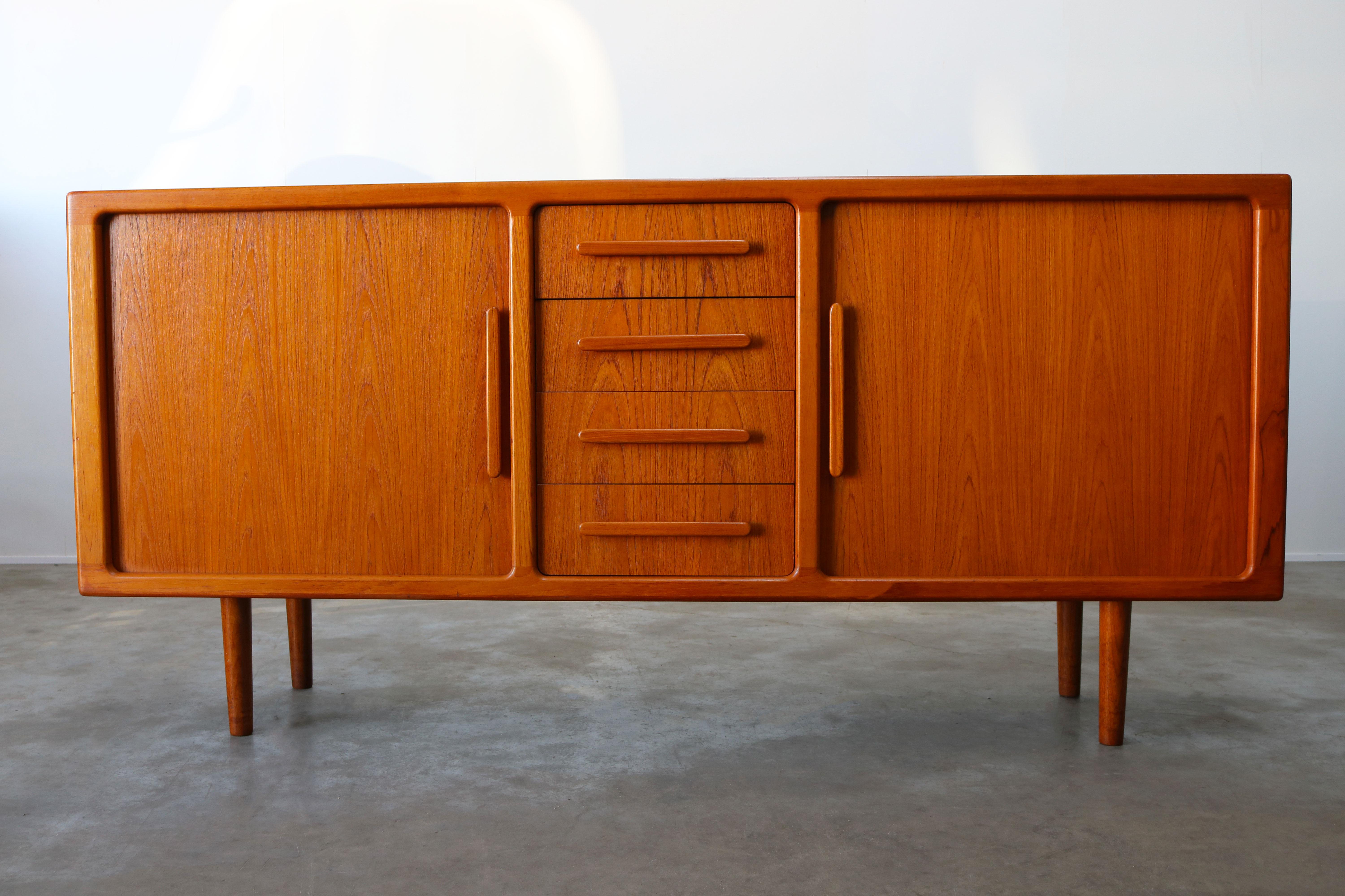 Danish design credenza / sideboard attributed to Johannes Andersen for the Danish furniture company Silkeborg. Wonderful piece of Danish design the sideboard has 2 tambour doors which disappear completely when opened and 4 drawers. The wood grain