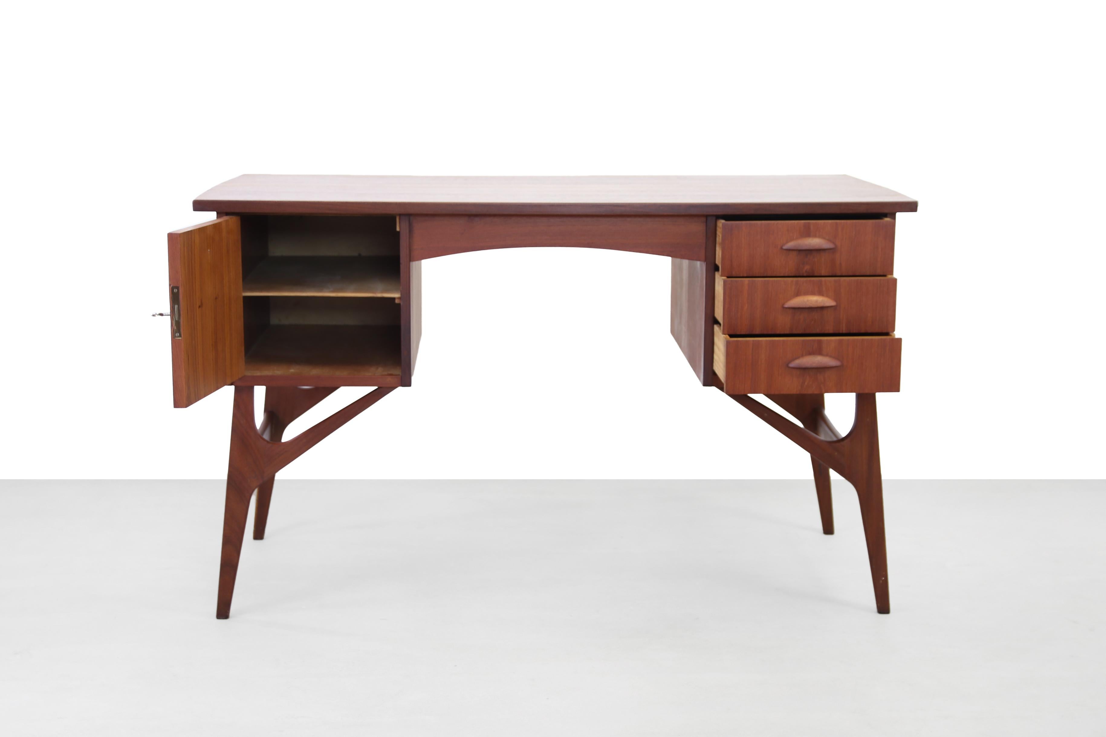 Stylish Danish design desk made of teak wood. Beautifully designed legs, 3 drawers and a storage compartment with a door for sufficient storage space and a teak veneer top with a slight curve on the side. The back of the desk is beautifully
