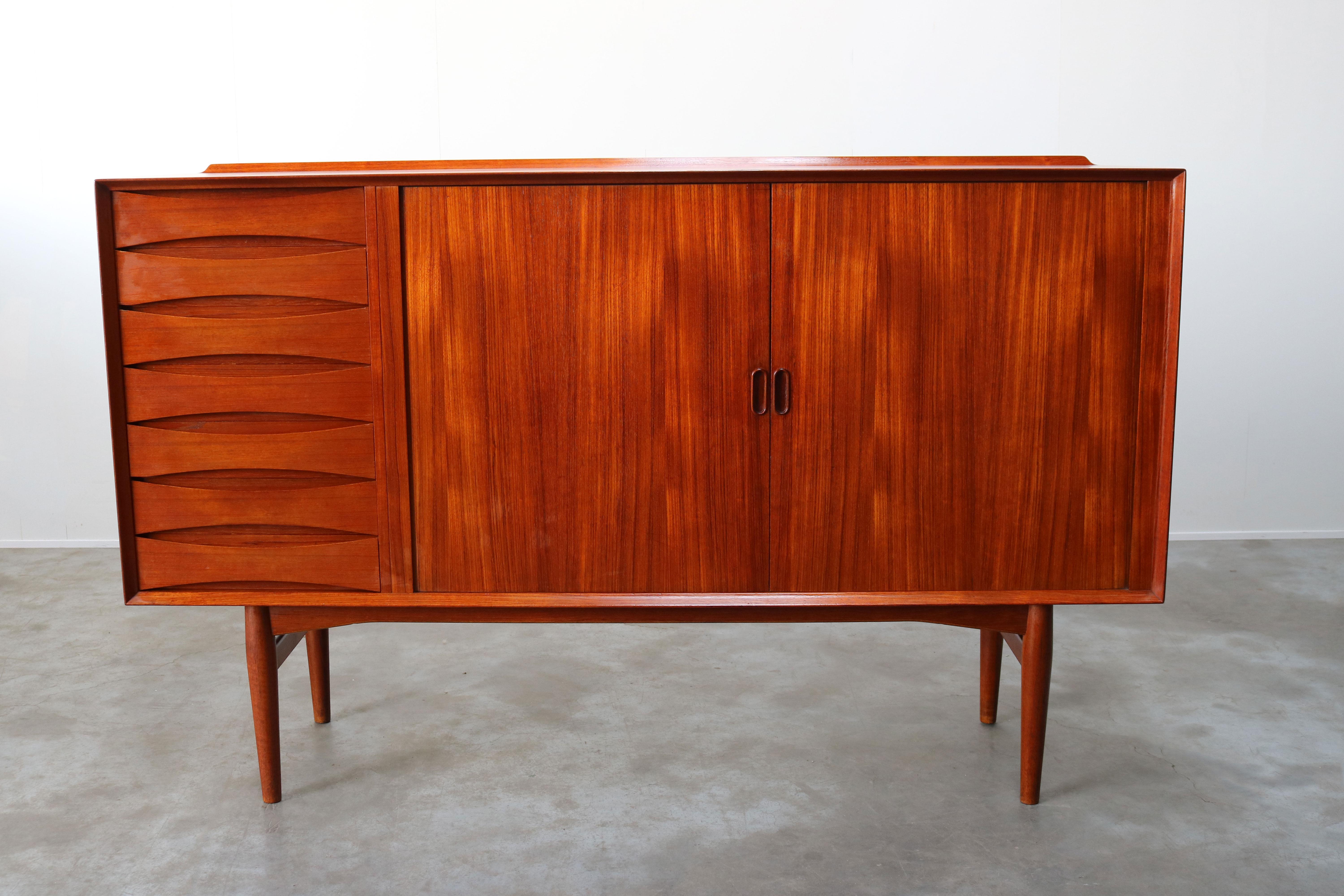 Wonderful Danish design highboard or cabinet model: OS63 by Arne Vodder for Sibast Mobler in the 1950s. This magnificent teak cabinet has multiple drawers and 2 tambour doors which disappear completely when opened. The cabinet is in solid teak with