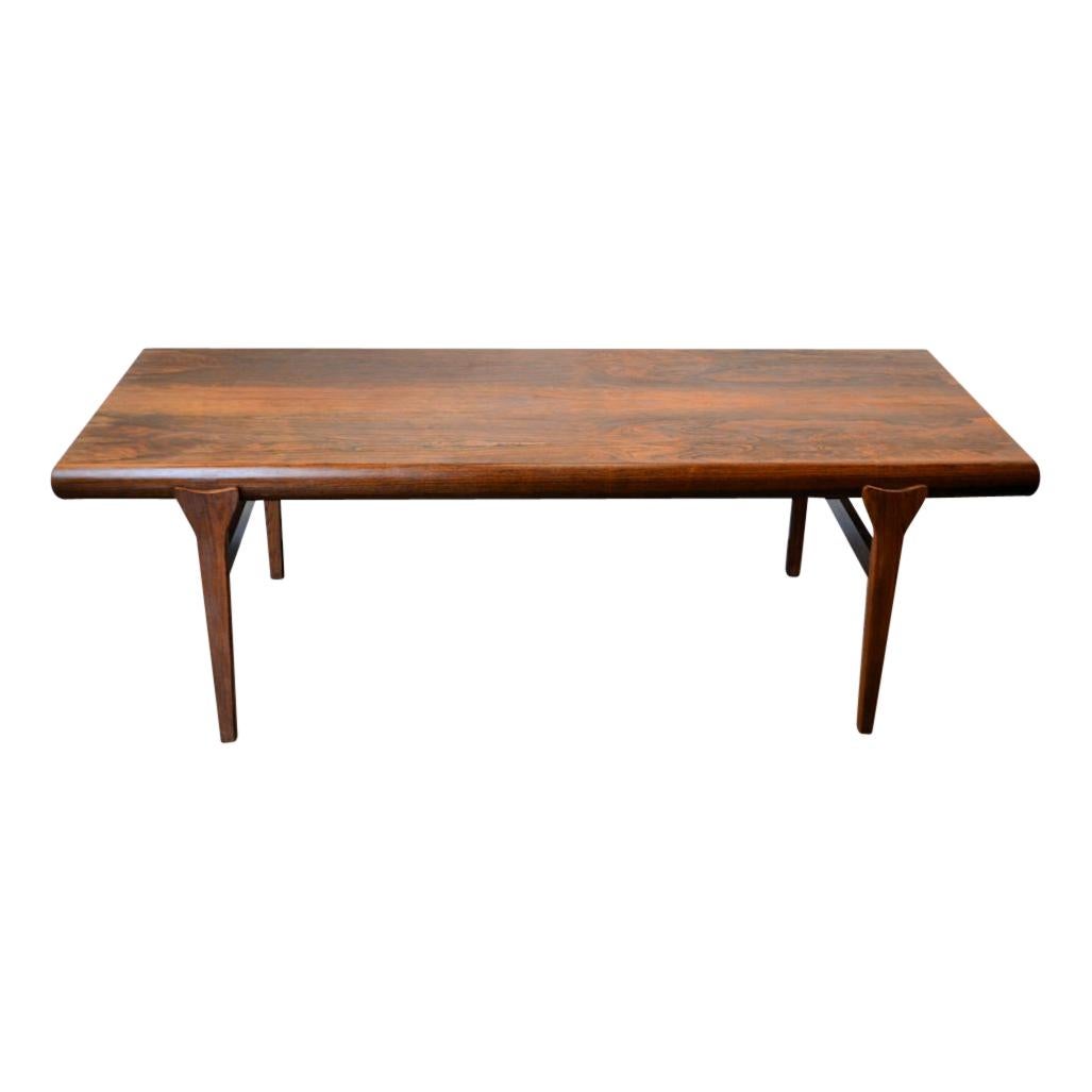 Vintage Brazilian rosewood/palisander coffee table designed by Johannes Andersen for Silkeborg Møbelfabrik, Denmark. This sturdy table features a gorgeous natural wood grain on its top, an extension element on the left end and some secret storage