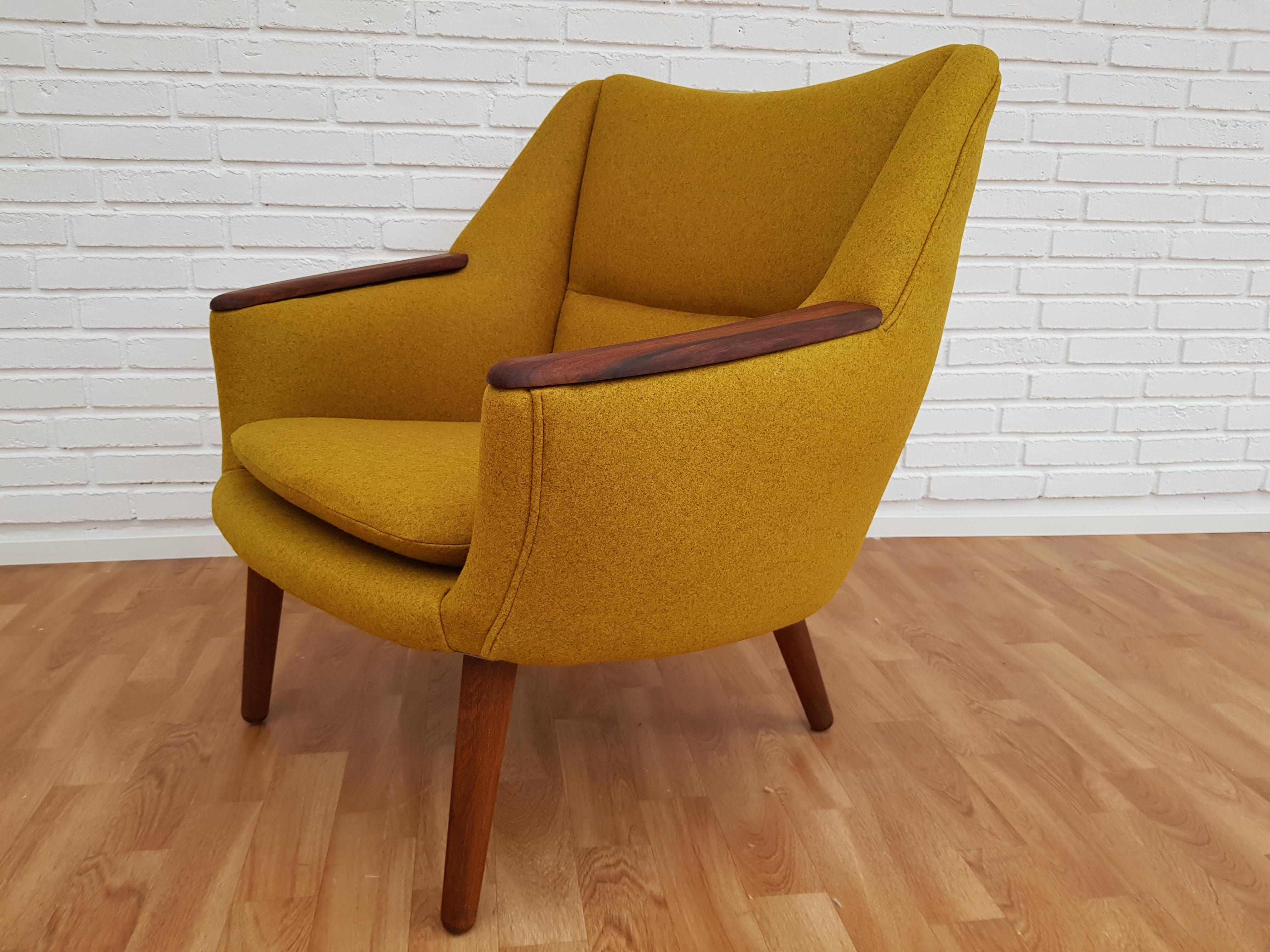 Danish designed retro armchair. Kurt Østervig model 58. Completely renovated (new upholstery) and upholstered in quality carry-yellow wool fabric by furniture craftsman at Retro Møbler Galleri. Oak legs and teak nails. Produced by Rolschau Møbler in