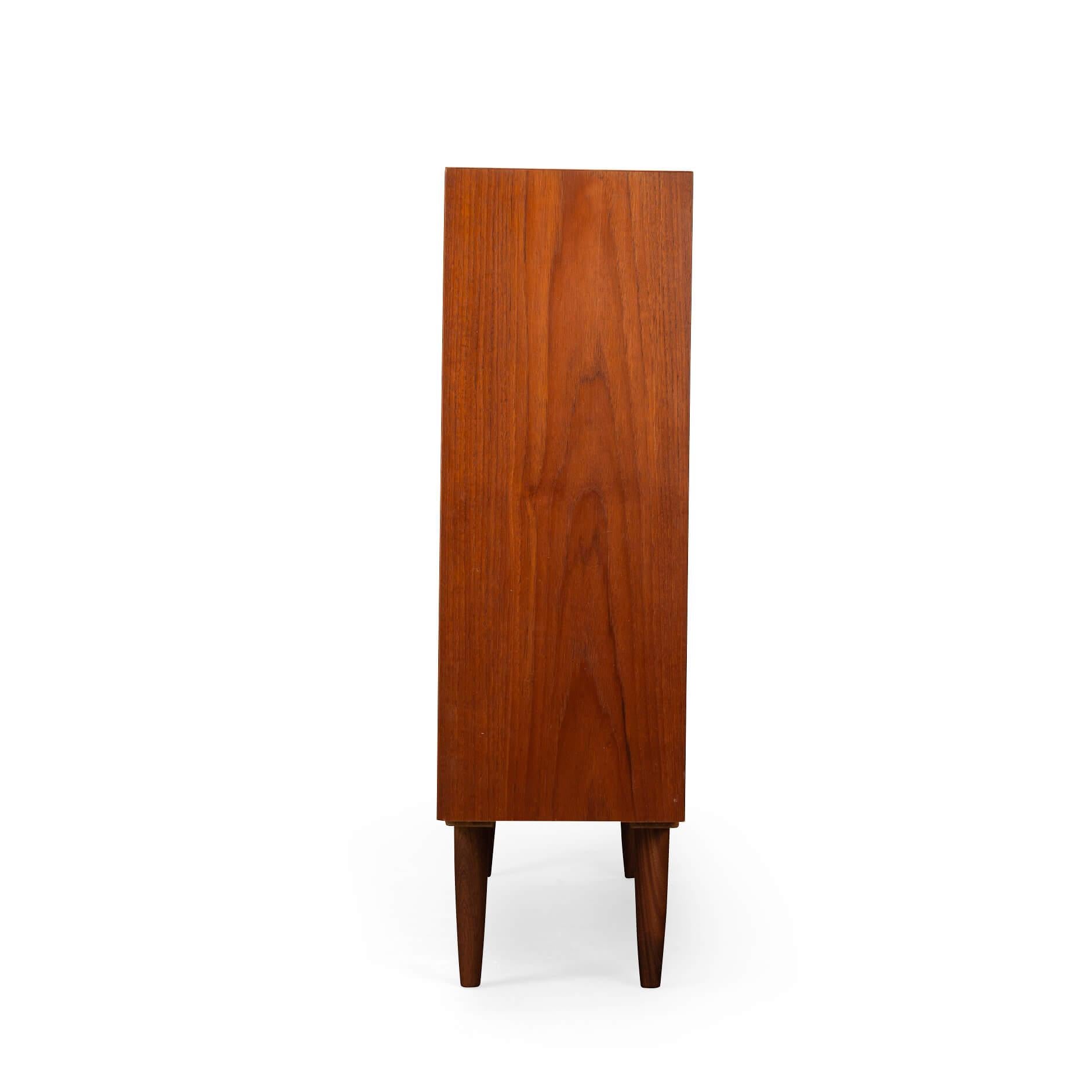 Danish Design: Bookcase
Danish tall bookcase in beautiful teak veneer. Designed by Carlo Jensen and made by Hundevad & Co. The sloping shelves are characteristic of Hundevad & Co bookcases.

This bookcase is in very good vintage condition and has a