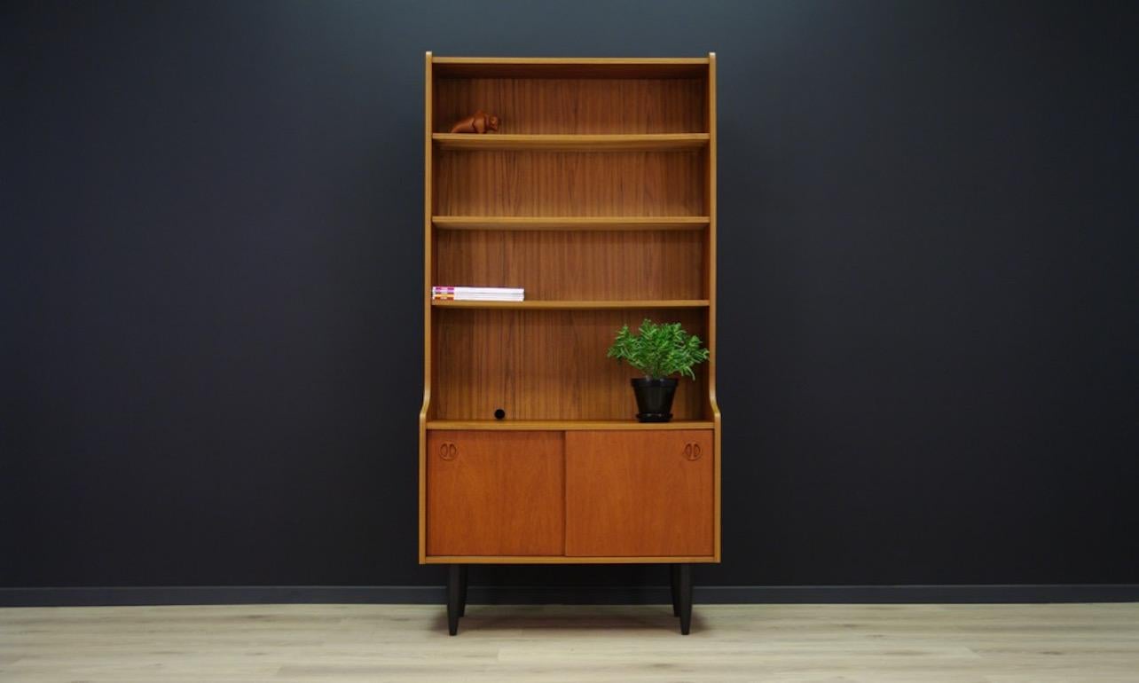 Vintage bookcase, cabinet from the 1960-1970s, covered with teak veneer. In the upper part of the item, shelf with the possibility of adjustment, while at the bottom part bar with shelf. Preserved in good condition (small dings and scratches),