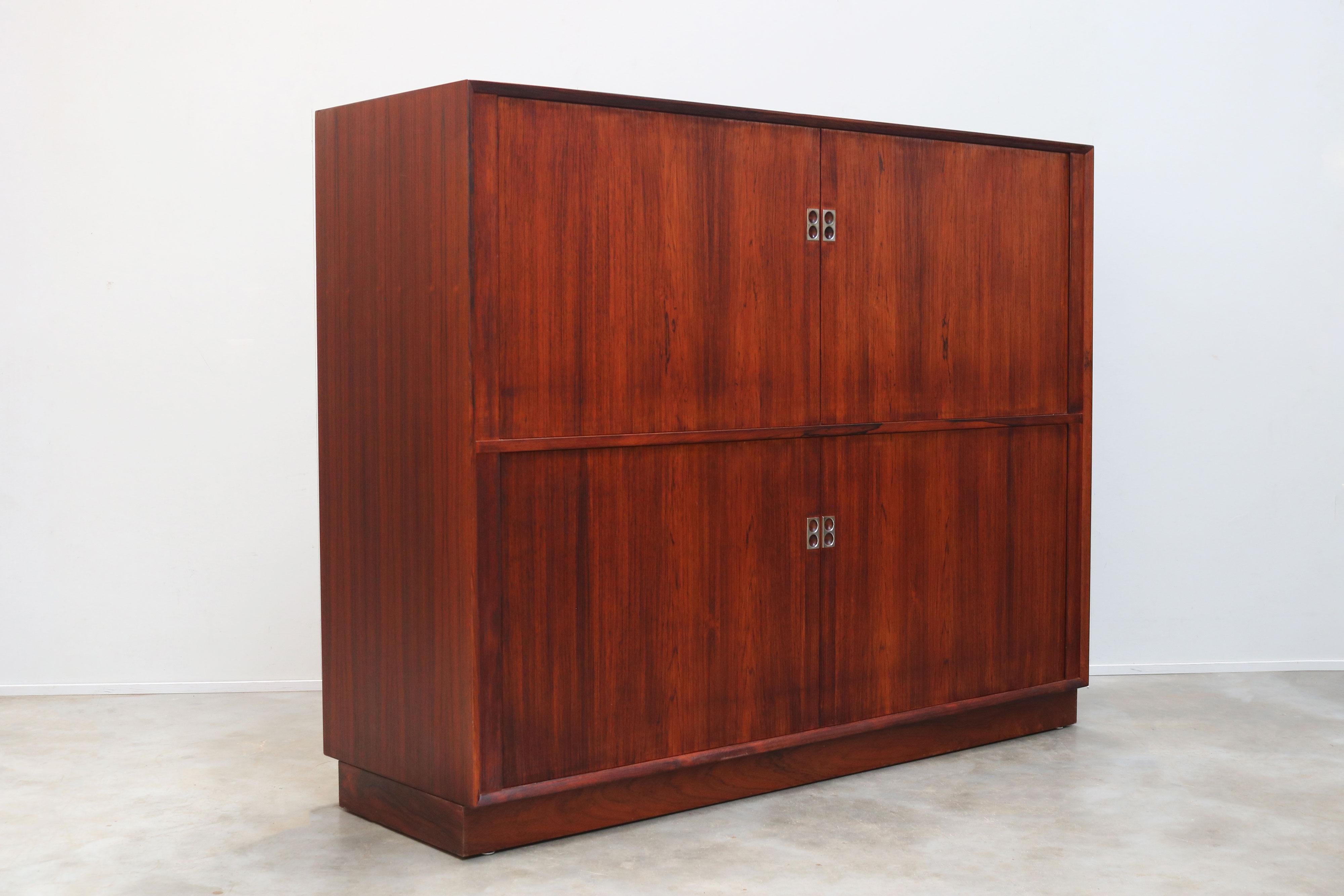 Prova l'epitome del lusso moderno di metà secolo con la credenza in palissandro con ante a tamburo di Arne Vodder, realizzata nel 1958 per Sibast Furniture. Questo squisito pezzo non è semplicemente una credenza, ma è una testimonianza di un design
