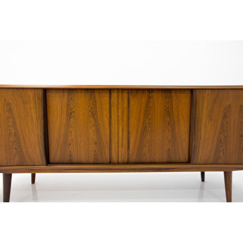 This Scandinavian Modern sideboard was designed and manufactured in Denmark at the turn of the 1950s and 1960s. In the front sliding doors hiding spacious cabinets. Maintained in a very good condition, it went through a small process of refreshing