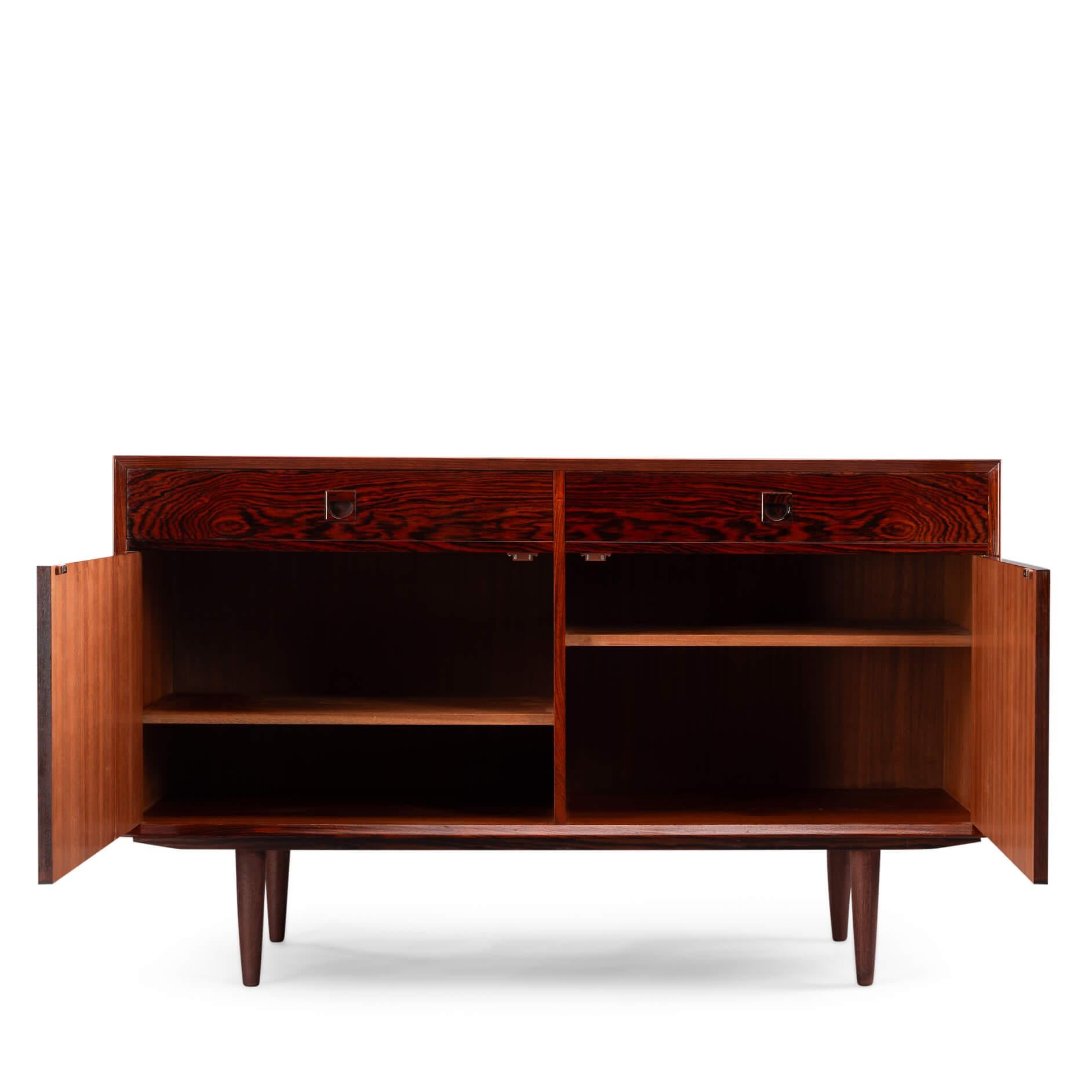 Deens design sideboard
Rosewood anybody?! This medium sized sideboard is all about the print and colour of the rosewood veneer. Very much an eye catcher in any modern and light interior. It has the design signature of Brouer all over it with it's