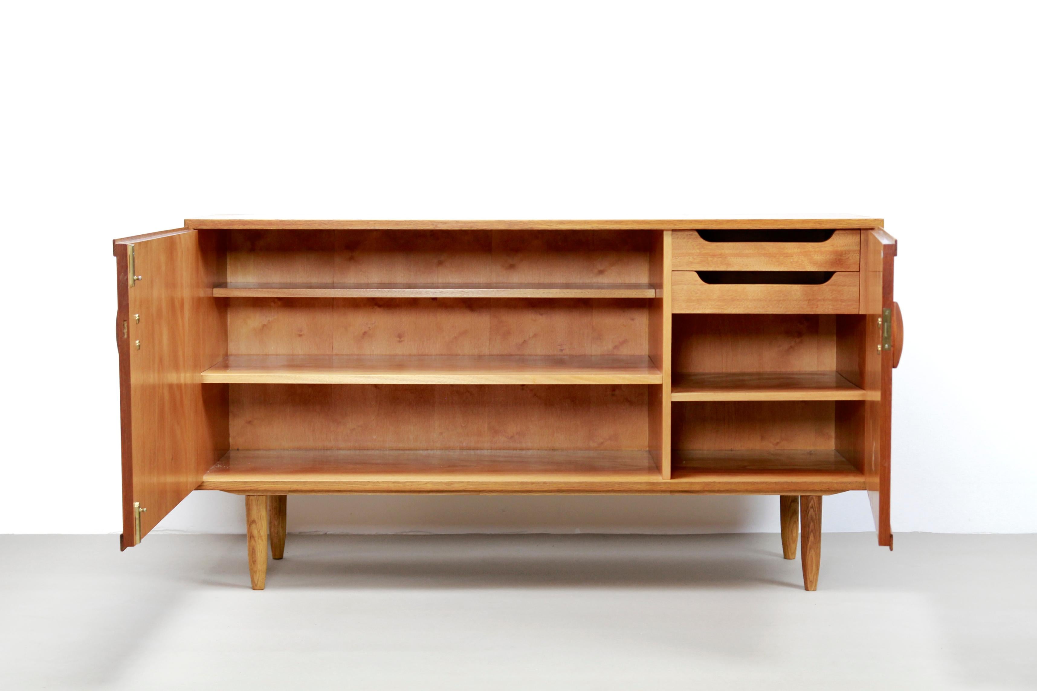Typical Mid-Century Modern designed sideboard made of a combination of teak and oakwood. This Minimalist sideboard is from Denmark and produced by Treman in the 1960s. The sideboard has two doors with a shelf and two drawers behind it and is 140 cm
