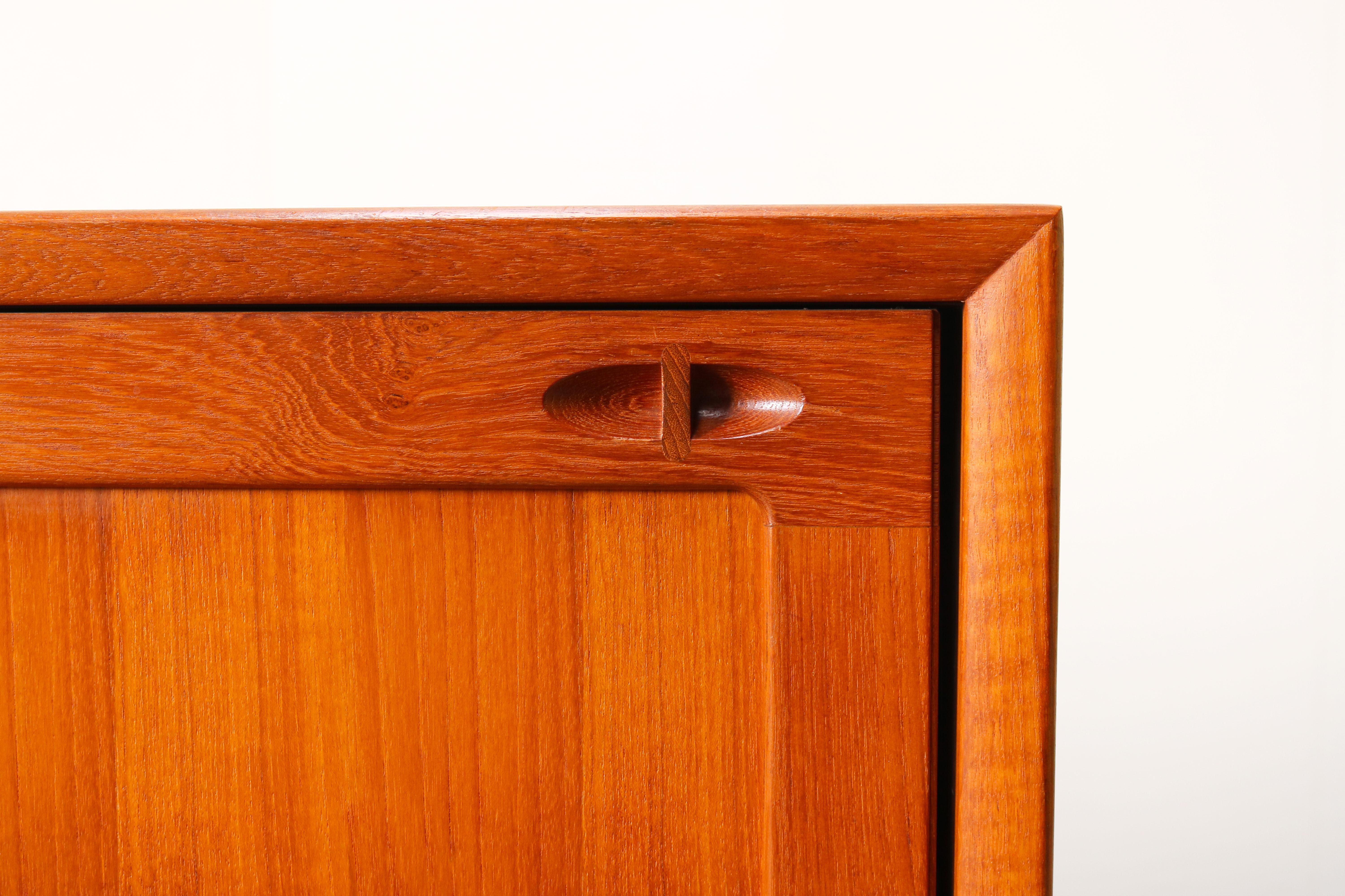 Magnificent Danish design sideboard designed by H.W. Klein for Bramin in the 1950s. The sideboard is made from solid teak wood and is famous for its combination between straight and organic lines with in particular the organic (solid wood) sculpted