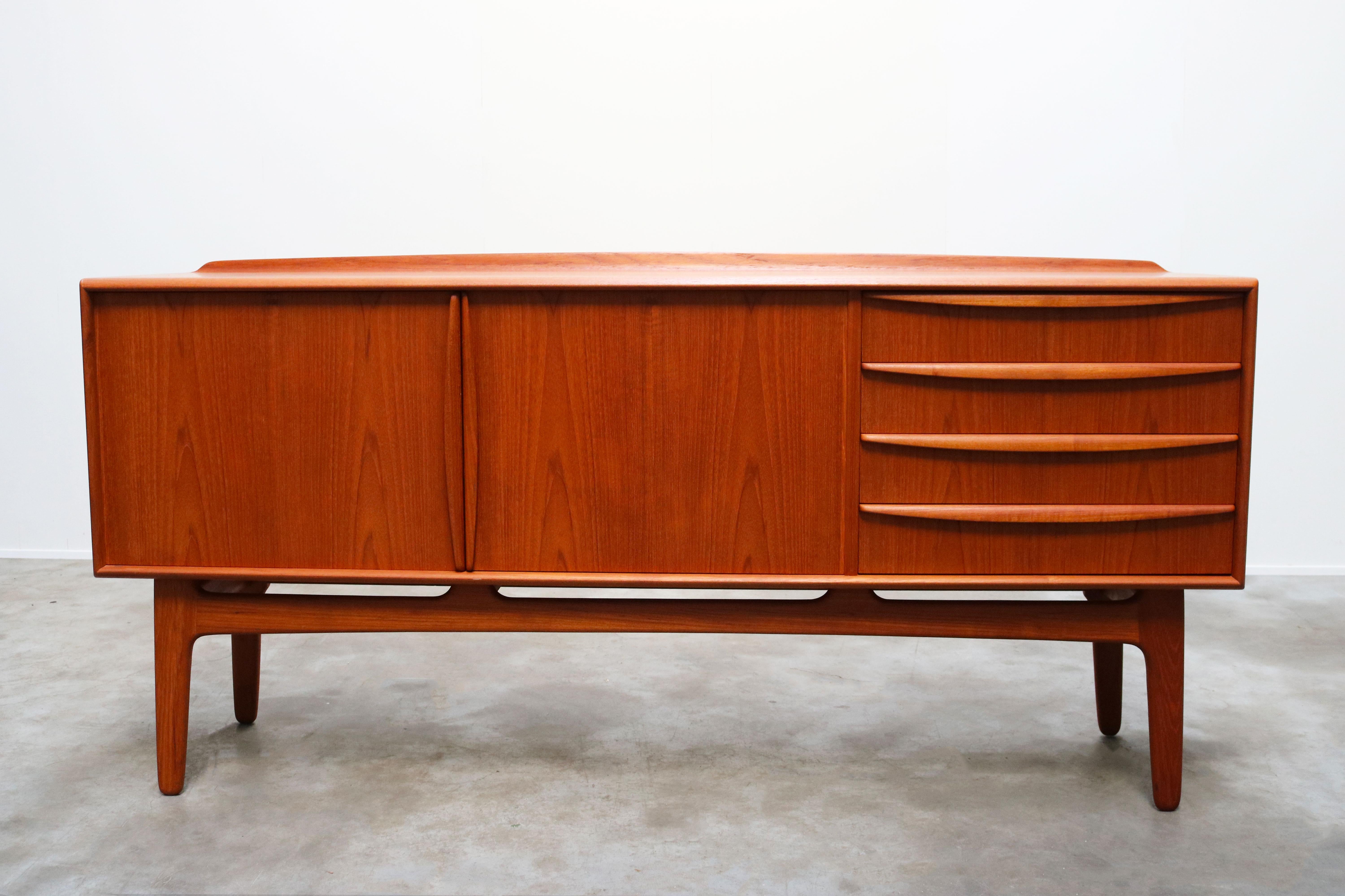 Magnificent Danish design sideboard / credenza by Svend Aage Madsen for K. Knudsen & Son 1950s. wonderful design with organic sculpted grips and base in solid teak. Multiple adjustable shelves and drawers which provide plenty of storage space and