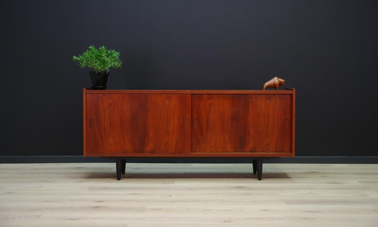 Stylish 1960s-1970s sideboard, Minimalistic form, Danish design, covered with teak veneer. Spacious interior with shelves behind sliding doors. Preserved in good condition (minor scratches and bruises), directly for use.

Dimensions: Height 64.5