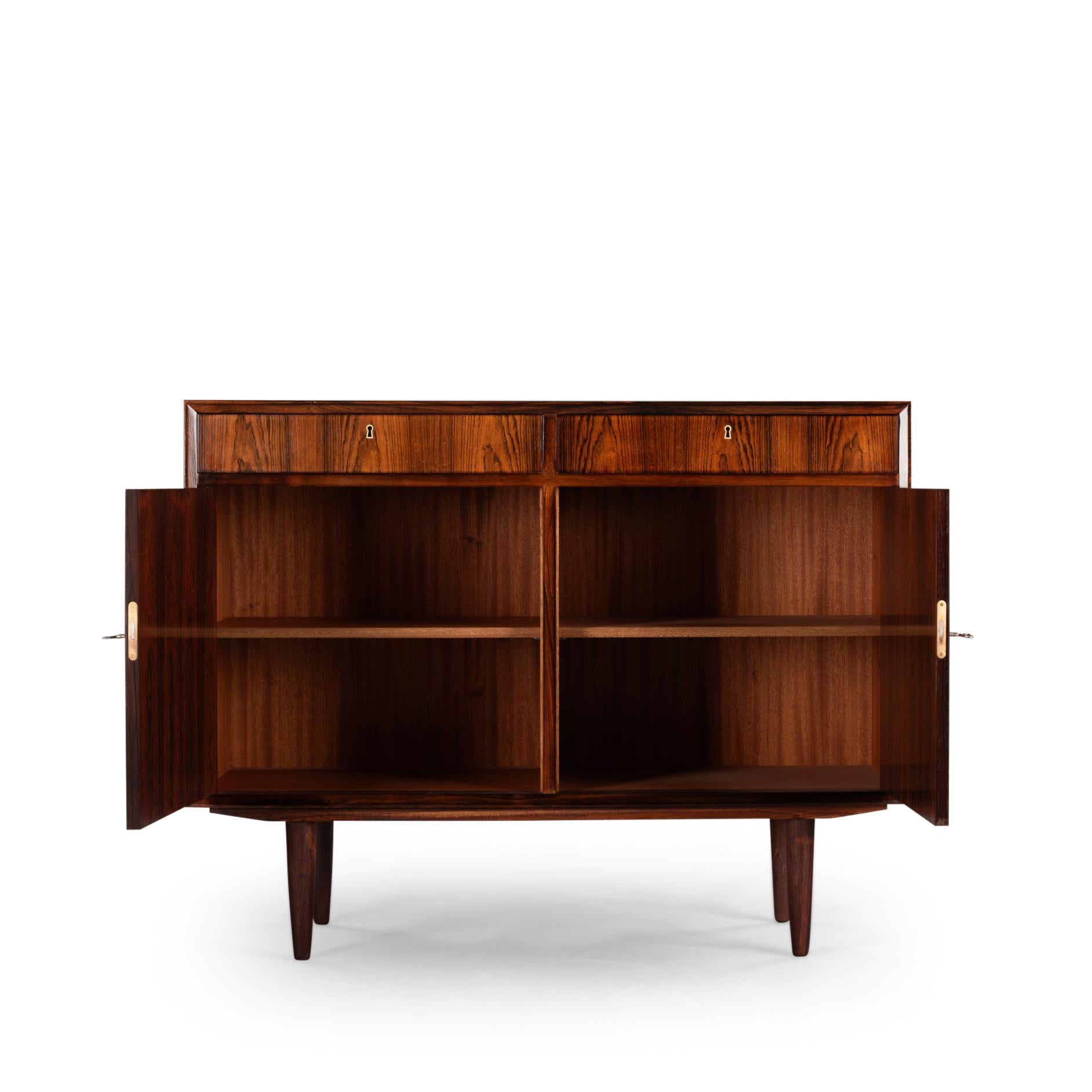 Credenza di design danese
C'è qualcuno che vuole il palissandro?! Questa credenza è realizzata grazie al disegno sottile e al colore caldo del palissandro. Rifinito con una splendida impiallacciatura in palissandro, questo mobile è dotato di grande
