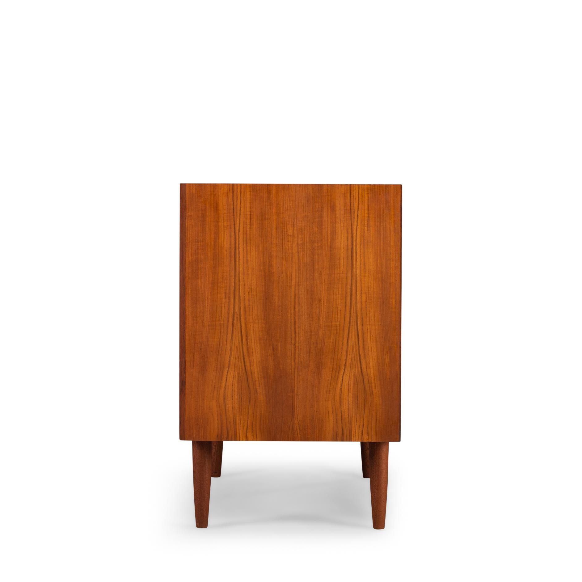 Small teak chest of drawers that can function well as sideboard designed by E. Brouer and manufactured by Brouer Møbelfabrik. An eye-catcher in every hallway, study or living! This sideboard has a whopping amount of drawers, ten in total all