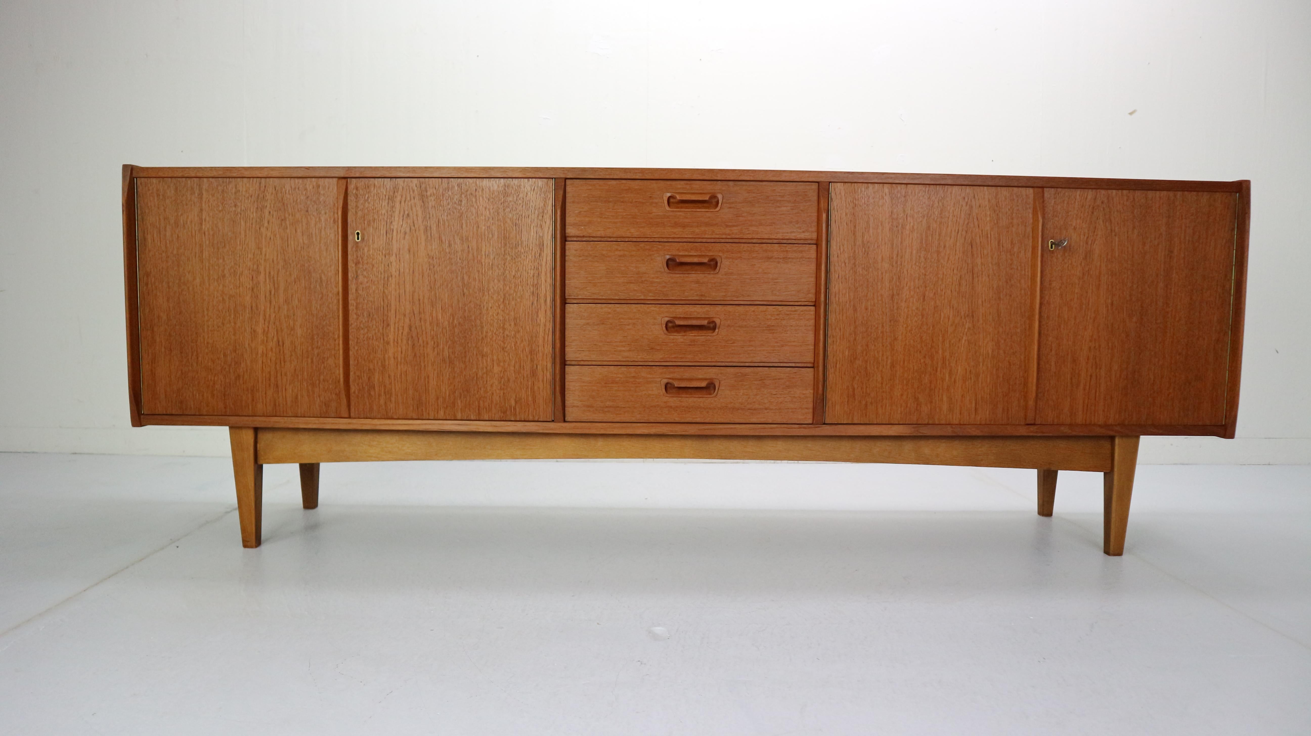 Beautifully curved Danish design sideboard made in 1960s, Denmark.
It's made of teak wood and has an original key and two locks on both sides.
220cm long sideboard has plenty storage for your items and unique accent for your vintage and modern