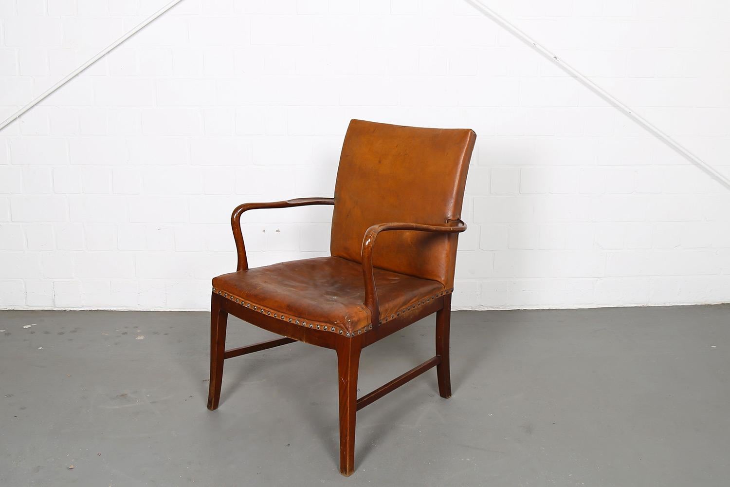 Danish design armchair, which is strongly reminiscent of designs by Frits Henningsen, Jacob Kjaer, Kaare Klint, Ib Kofod-Larsen or Ole Wanscher. Probably designed and produced in the 1930s or 1940s. Thick, brown leather and beautifully crafted