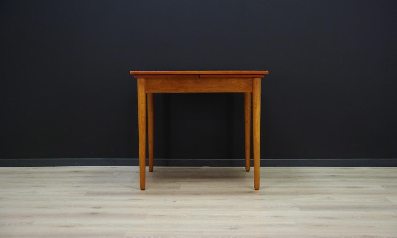 Amazing dining table from the 1960s-1970s, a beautiful minimalist form, Danish design. Tabletop veneered with teak, solid teak legs. Table has two inserts under the top. Preserved in good condition (visible bruises and traces), directly for