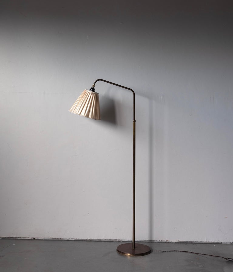 A functionalist floor lamp, designed and produced in Denmark, 1940s. Features brass. Brand new lampshade.

Stated dimensions with lampshade attached as is illustrated in the primary image.