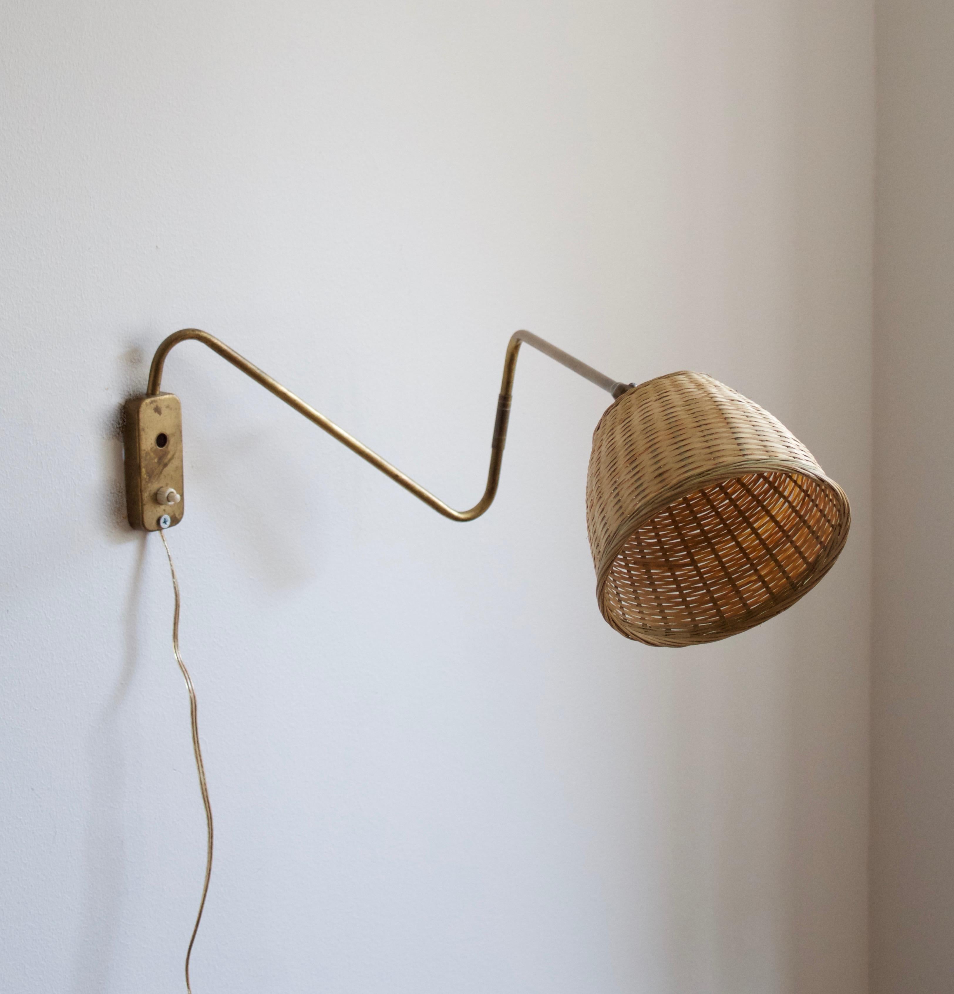 A small functionalist wall light / task light, designed and produced in Denmark, 1940s. Features brass and Bakelite socket. Assorted vintage rattan lampshade.

Stated dimensions with lampshade attached as is illustrated in the primary image.