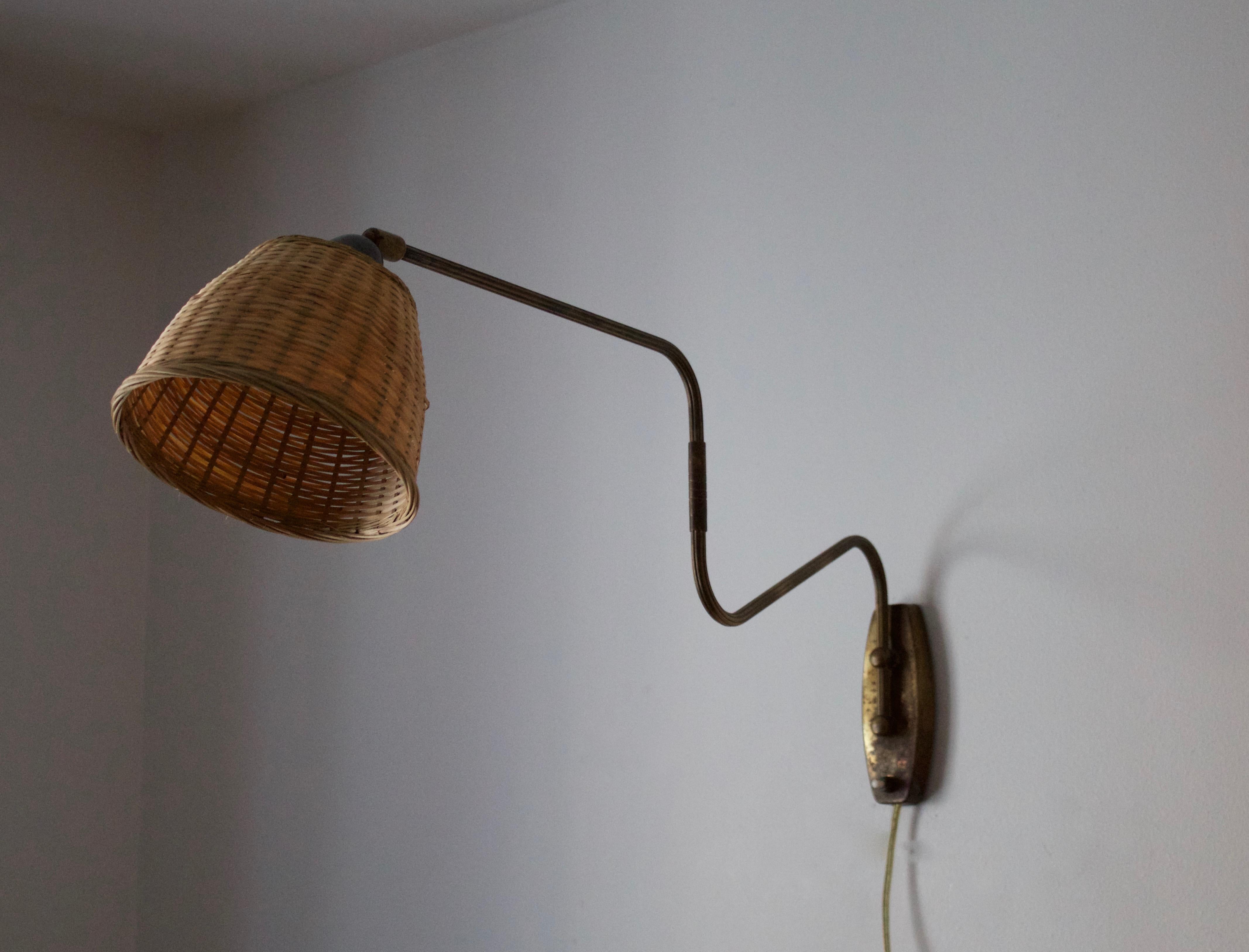 A small functionalist wall light / task light, designed and produced in Denmark, 1940s. Features brass and Bakelite socket. Assorted Vintage rattan lampshade.

Stated dimensions with lampshade attached as is illustrated in the primary image.