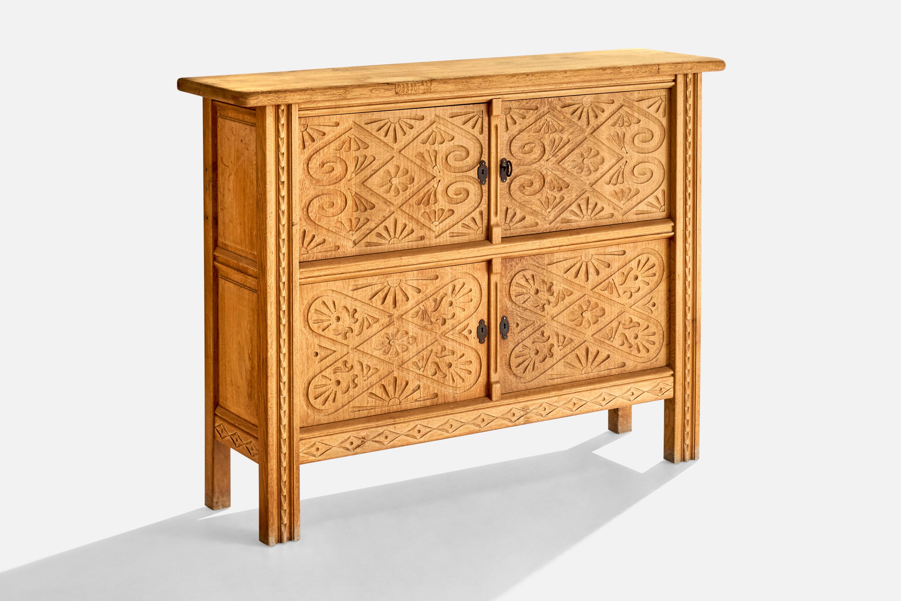 A carved oak and iron cabinet designed and produced in Denmark, c. 1960s.
