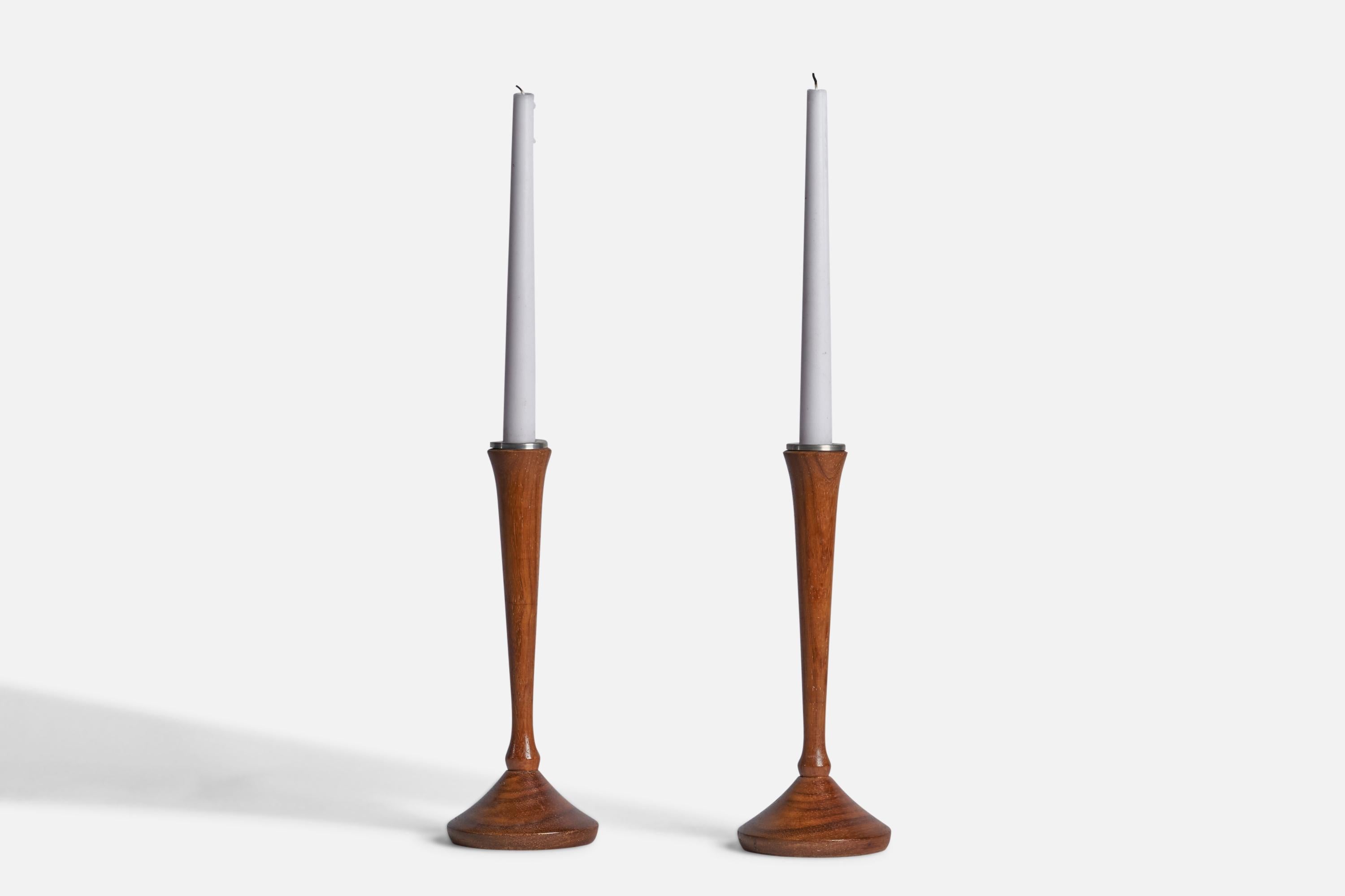 A pair of walnut and metal candlesticks designed and produced in Denmark, 1950s.

Holds 0.75” candles