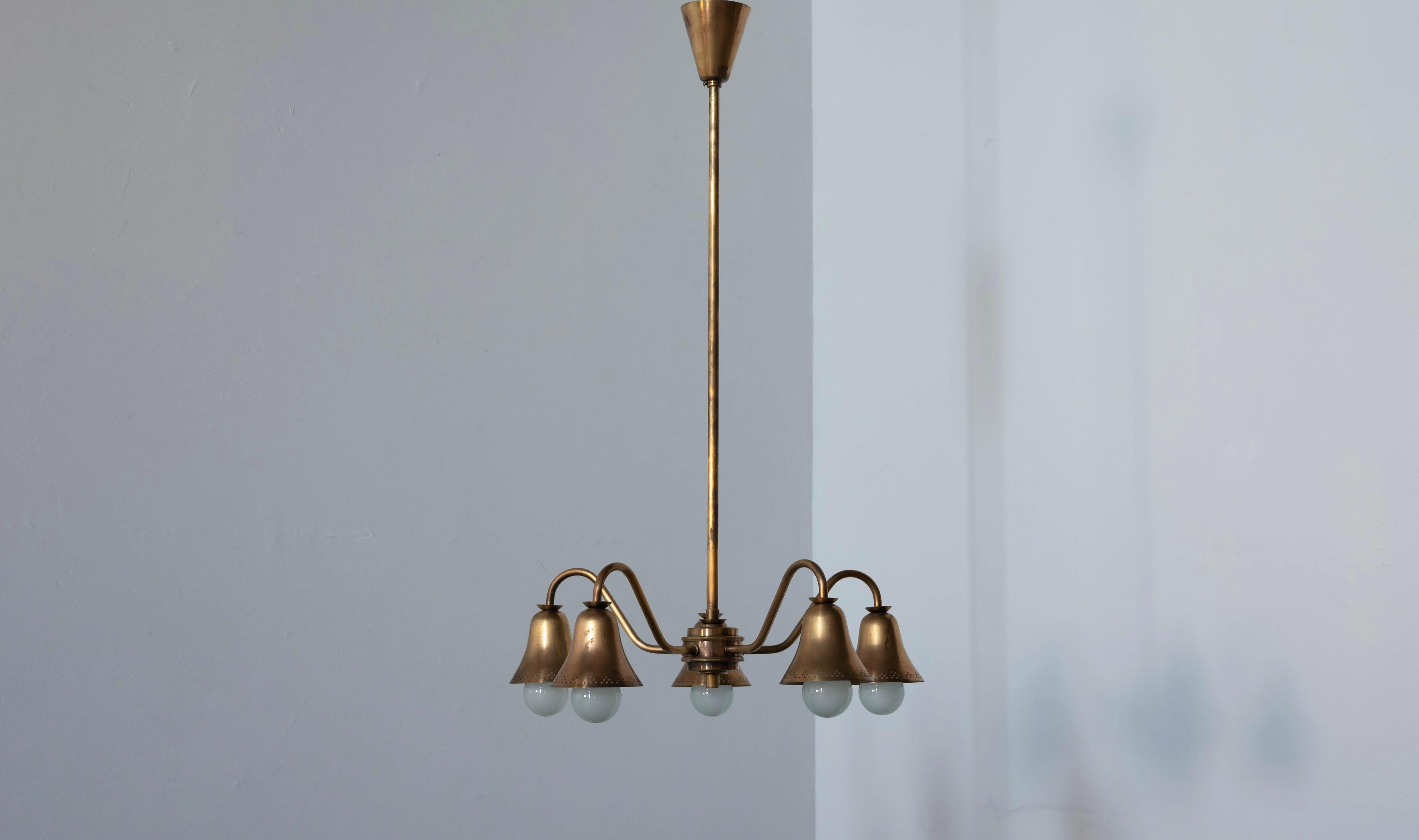 A five-armed chandelier executed in brass. Designed and produced in Denmark, 1930s.

Stated dimensions exclude installed lampshades illustrated.